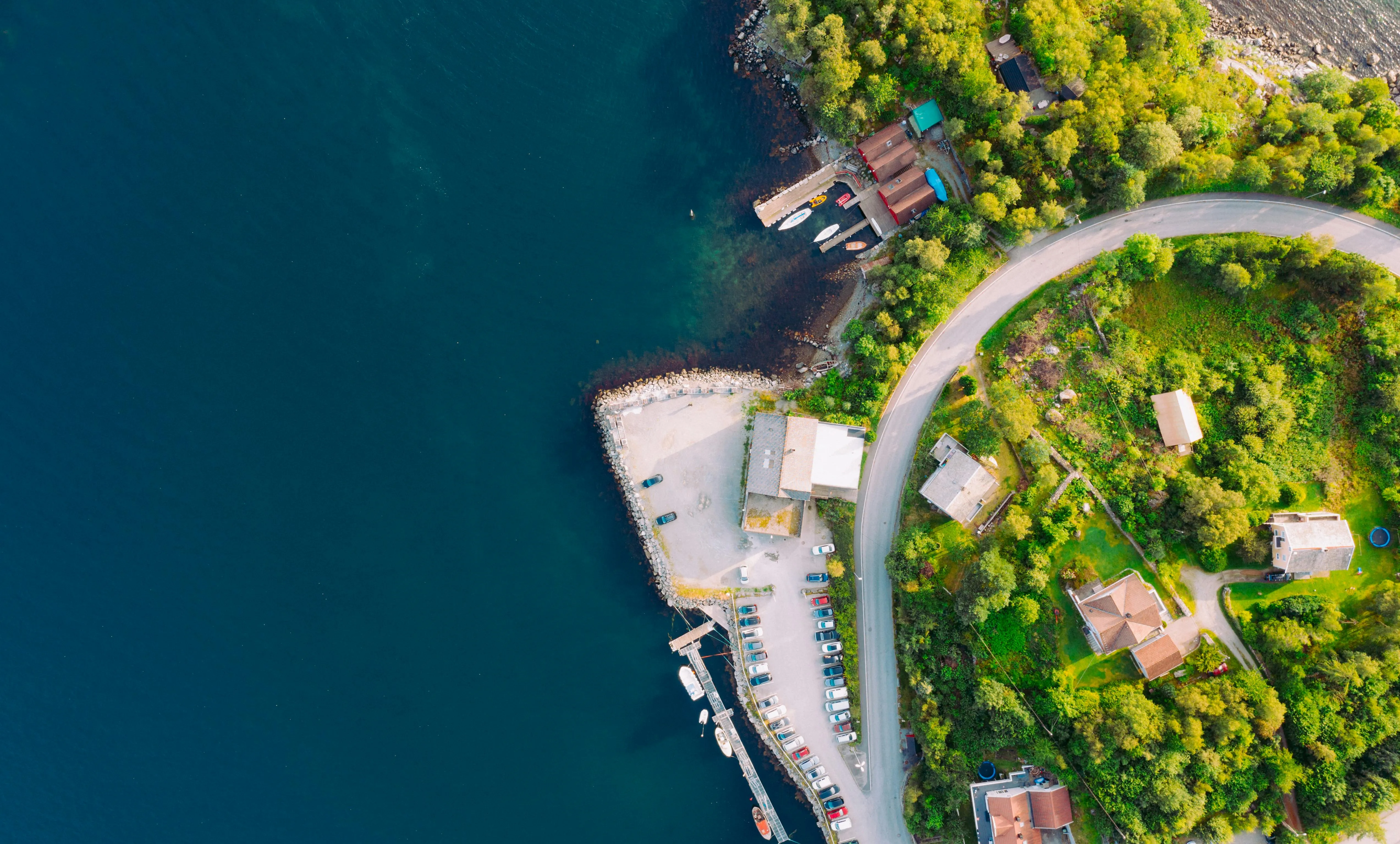 Coastline Neighborhood Beside a Curved Blue Road Wallpaper