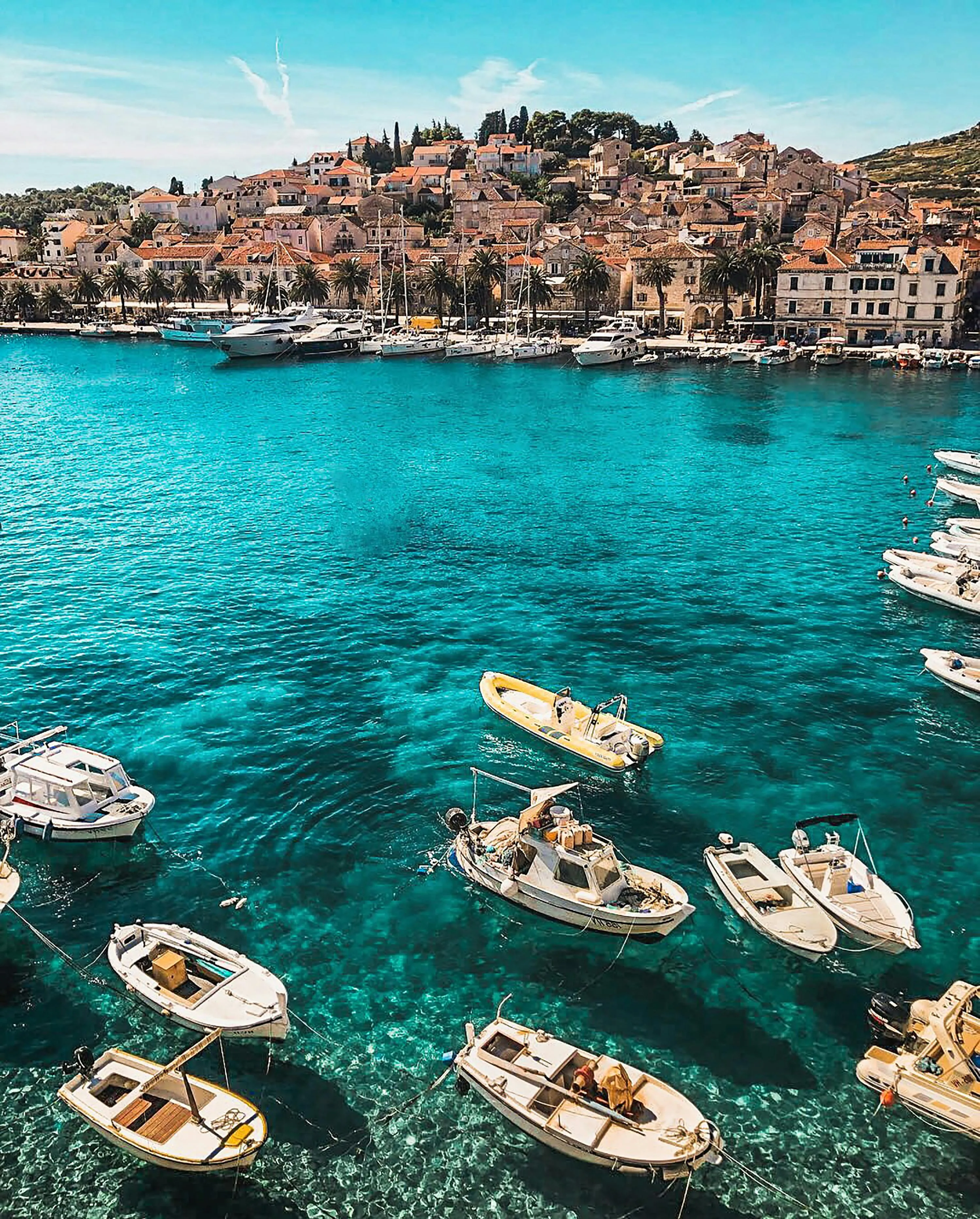 Colorful Boats Floating on Clear Blue Harbor Water View