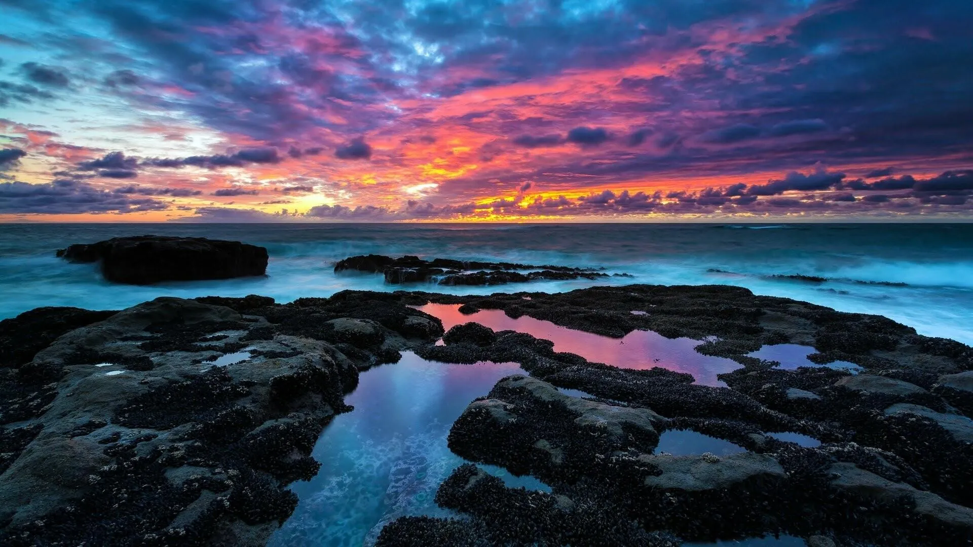 Colorful Sky over Rocky Coast with Reflecting Seawater
