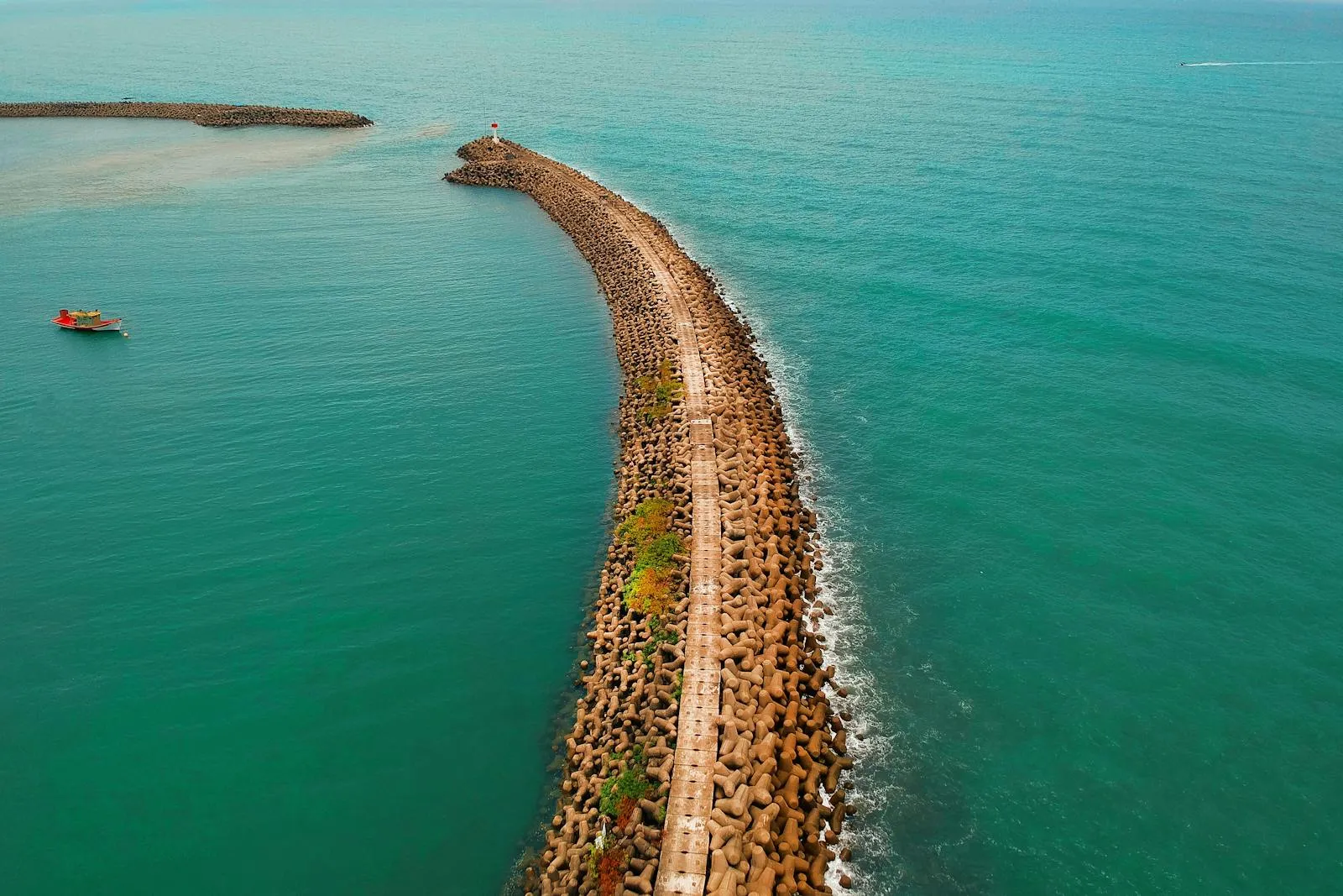 Curved Sea Breakwater in the Calm Turquoise Ocean Wallpaper