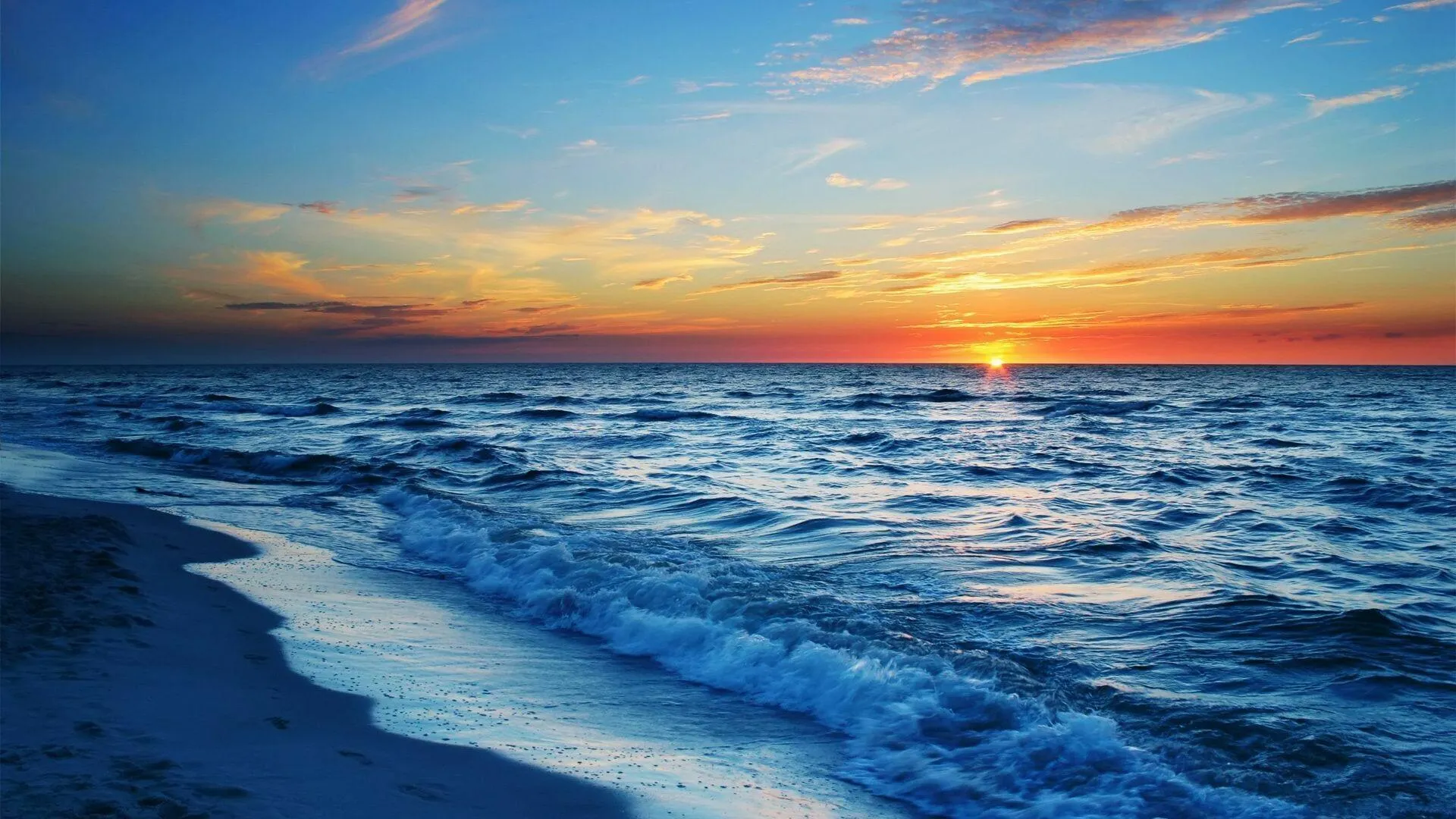 Gentle Waves Rolling Onto the Sandy Shore at a Golden Sunset