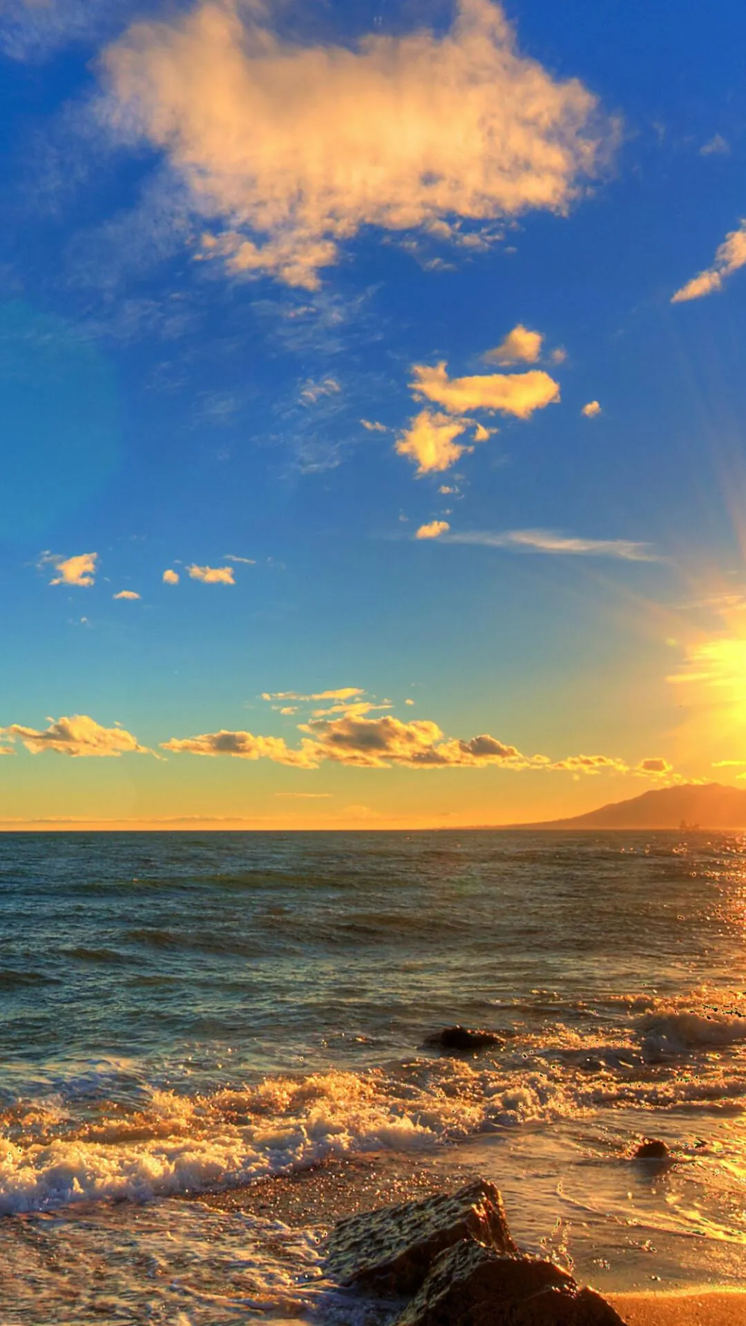Golden Sunset over Rocky Shore and Gentle Ocean Waves