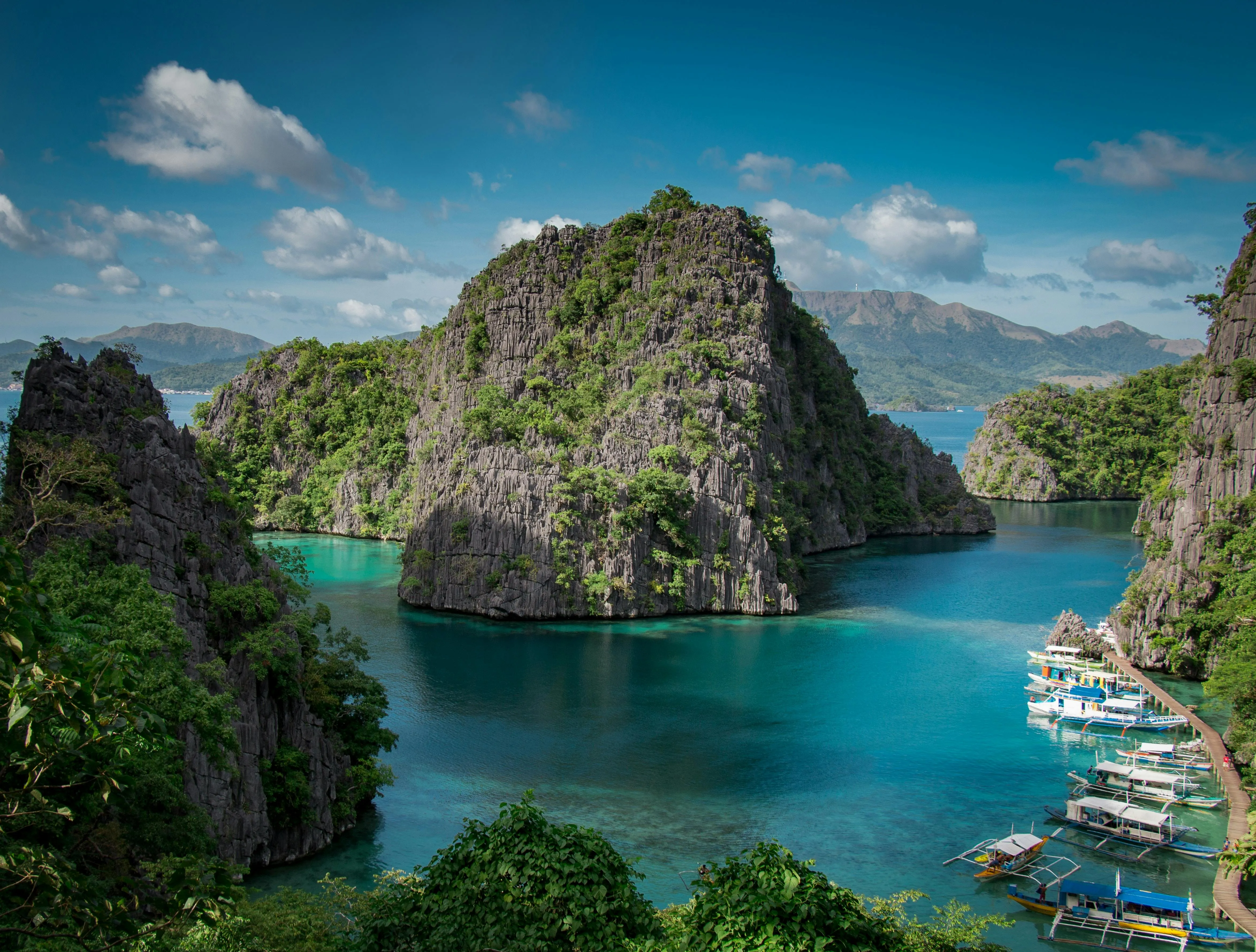 Island with Boats and Towering Limestone Cliffs Wallpaper