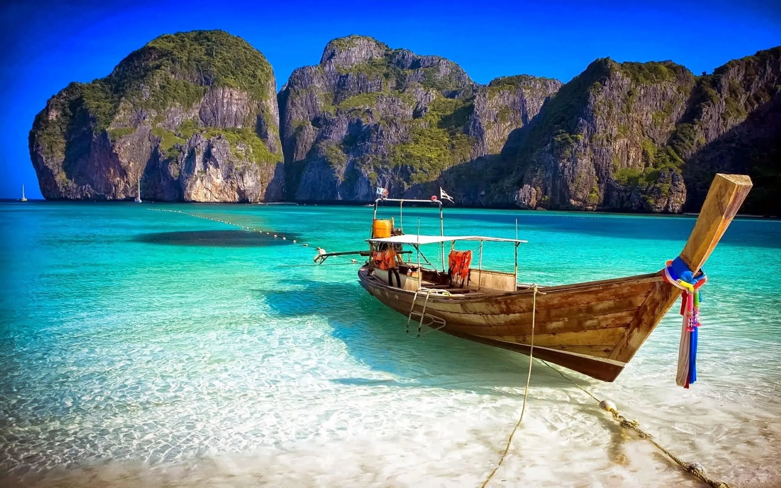 Longtail Boat Floating on the Blue Sea by a Rocky Island