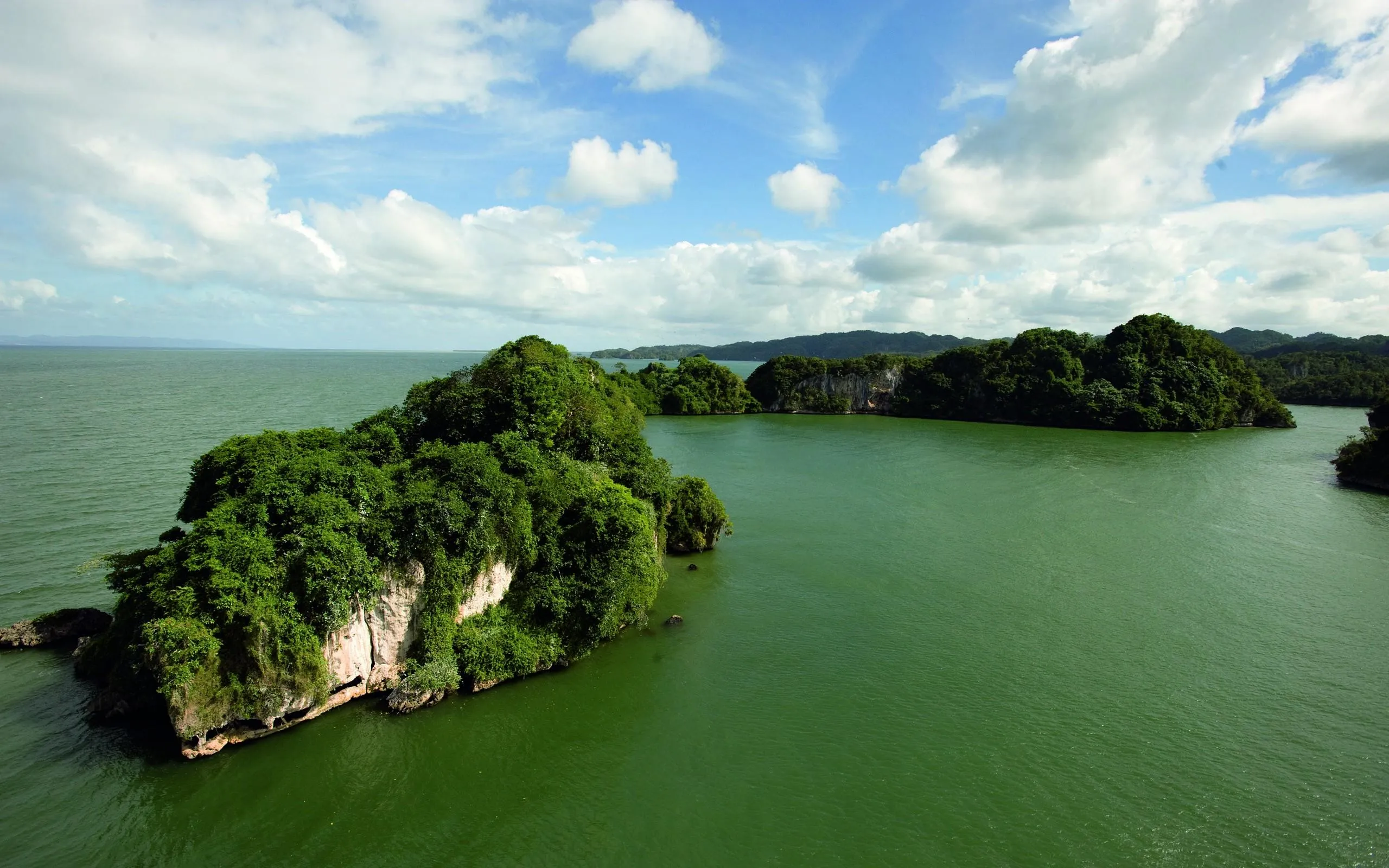 Lush Green Island Cliffs with Clear Sea Free HD Wallpaper