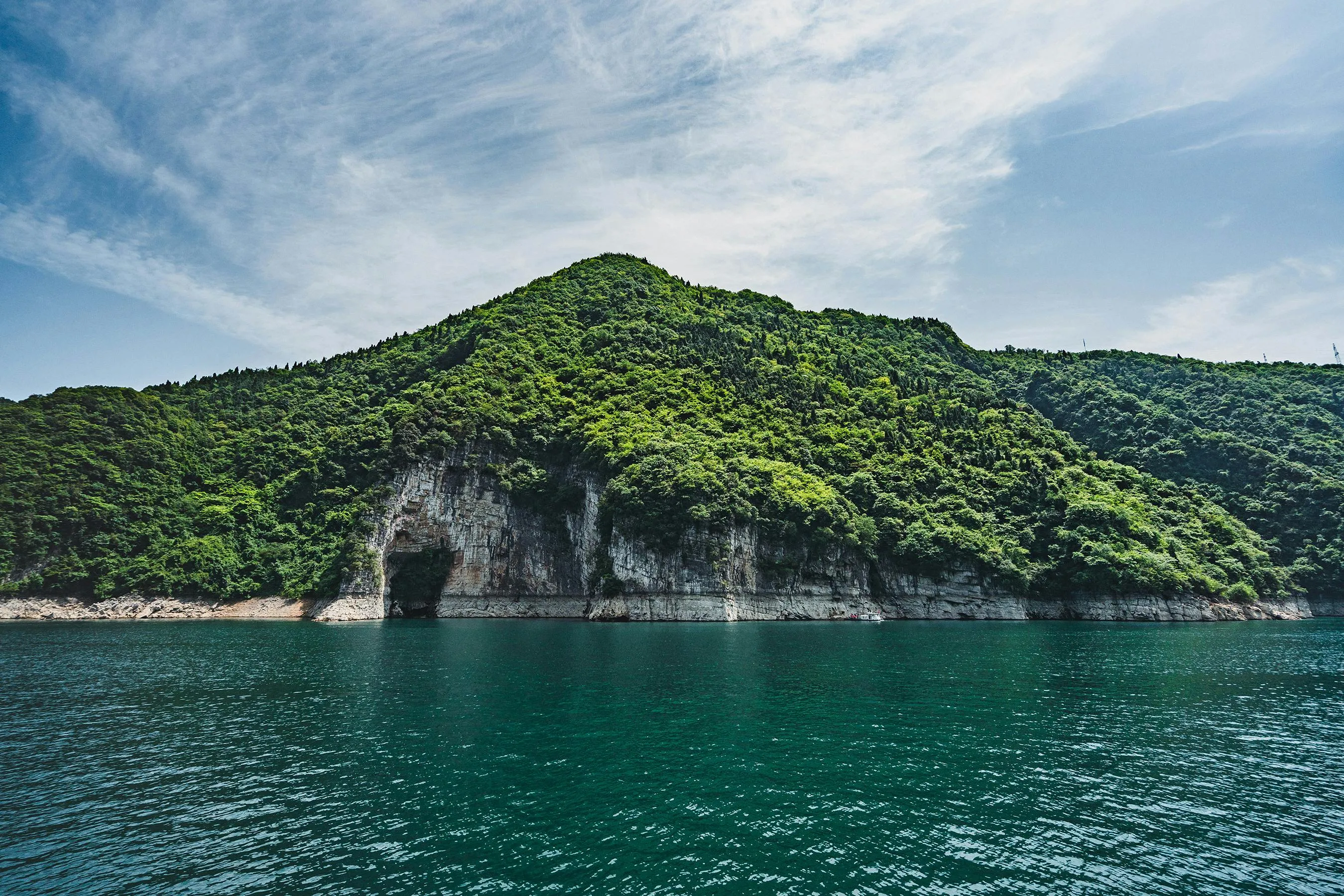 Lush Green Island with Cliffs Rising from the Clear Water