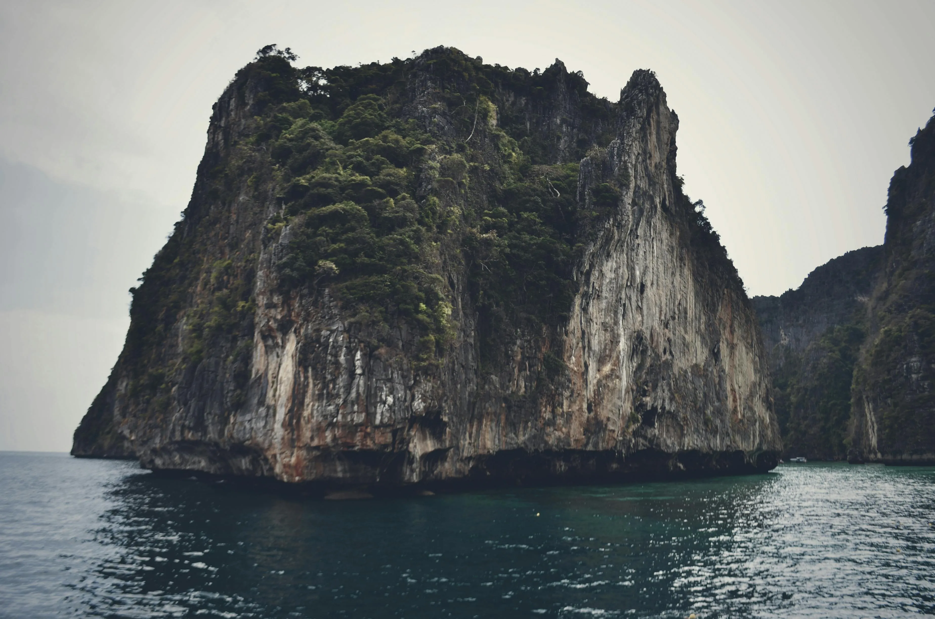 Massive Rock Formation Rising from the Blue Coastal Waters