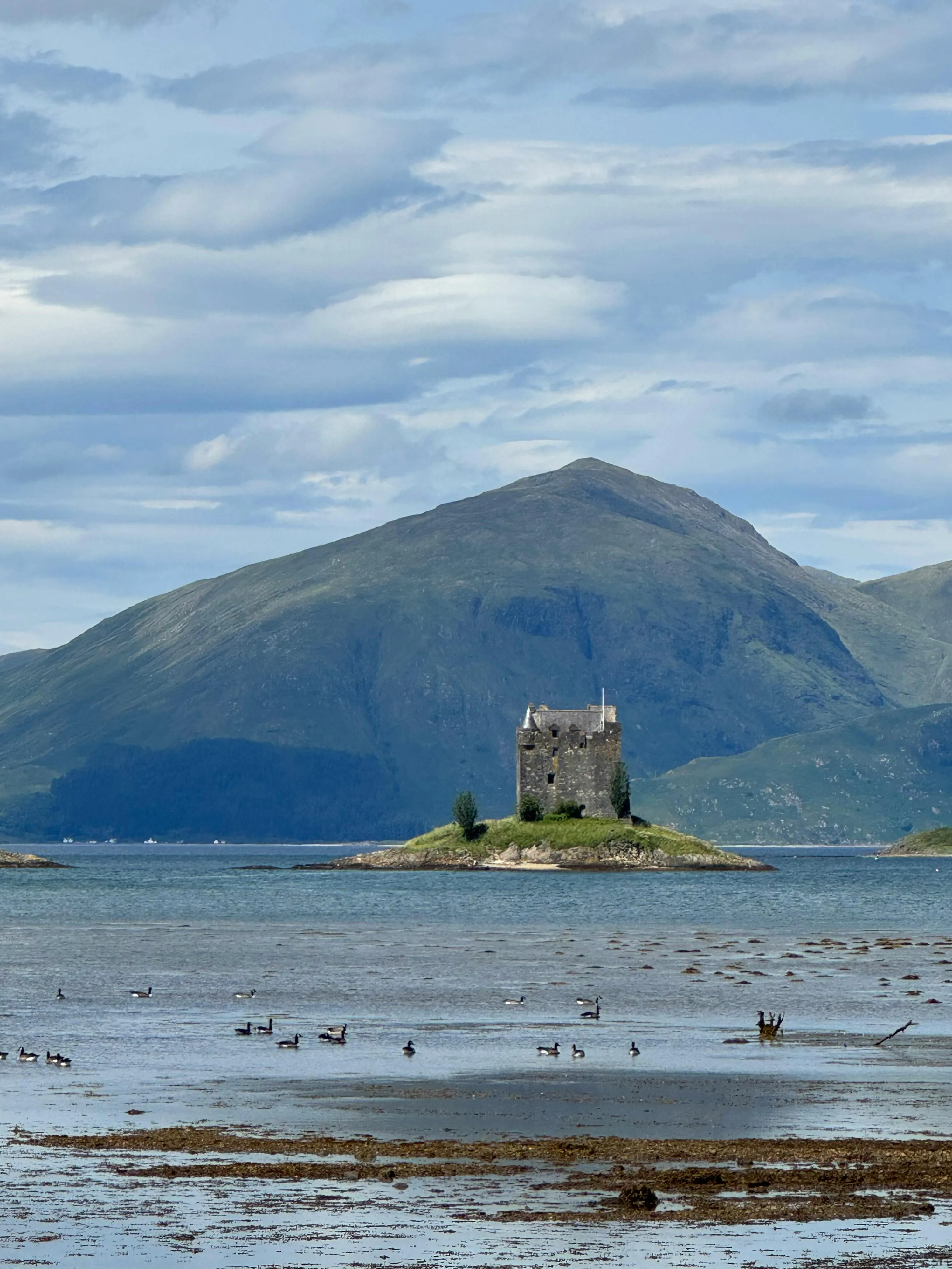 Old Stone Castle by the Beach with a Mountain View Wallpaper