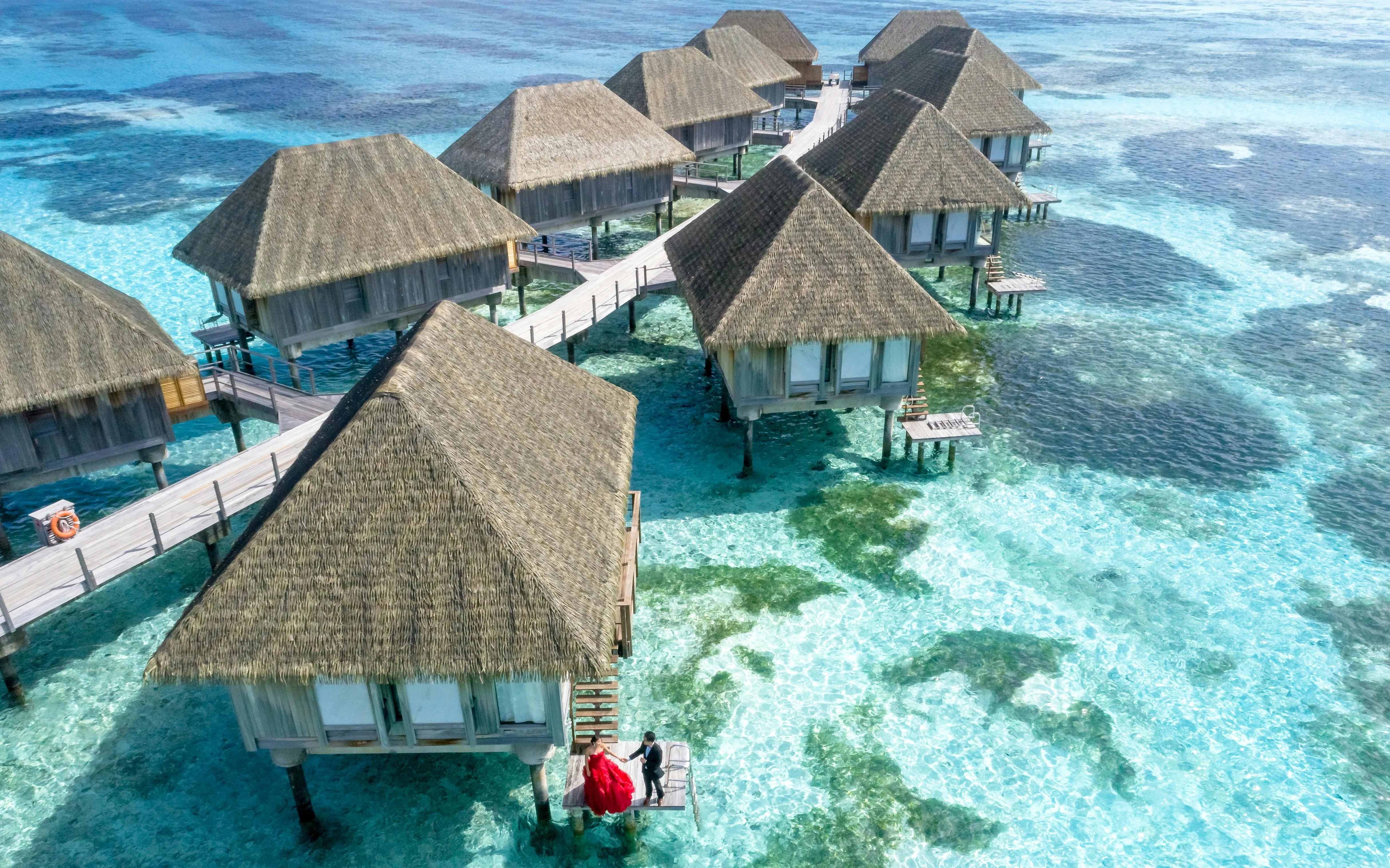 Overwater Bungalows Above Clear Turquoise Sea Free Wallpaper