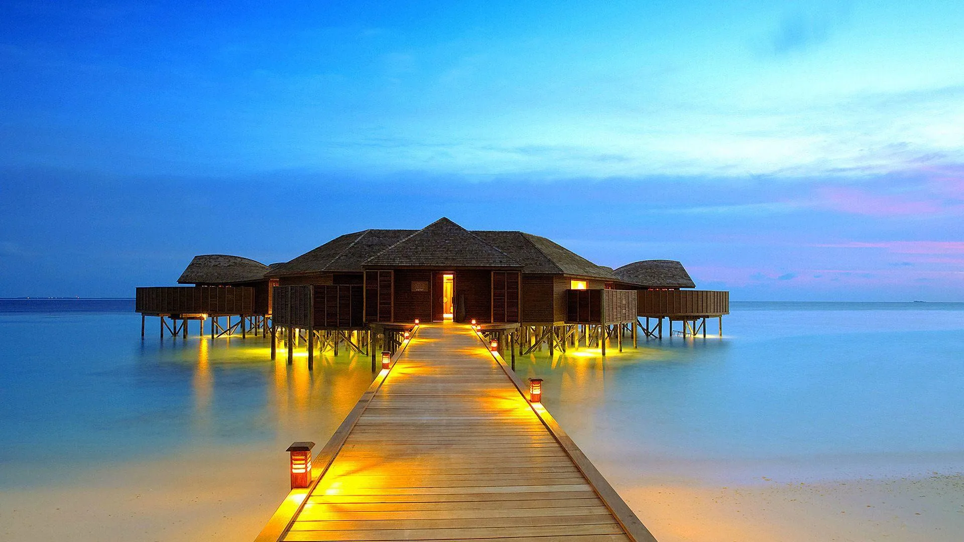 Overwater Villas Glowing in Evening on a Calm Ocean