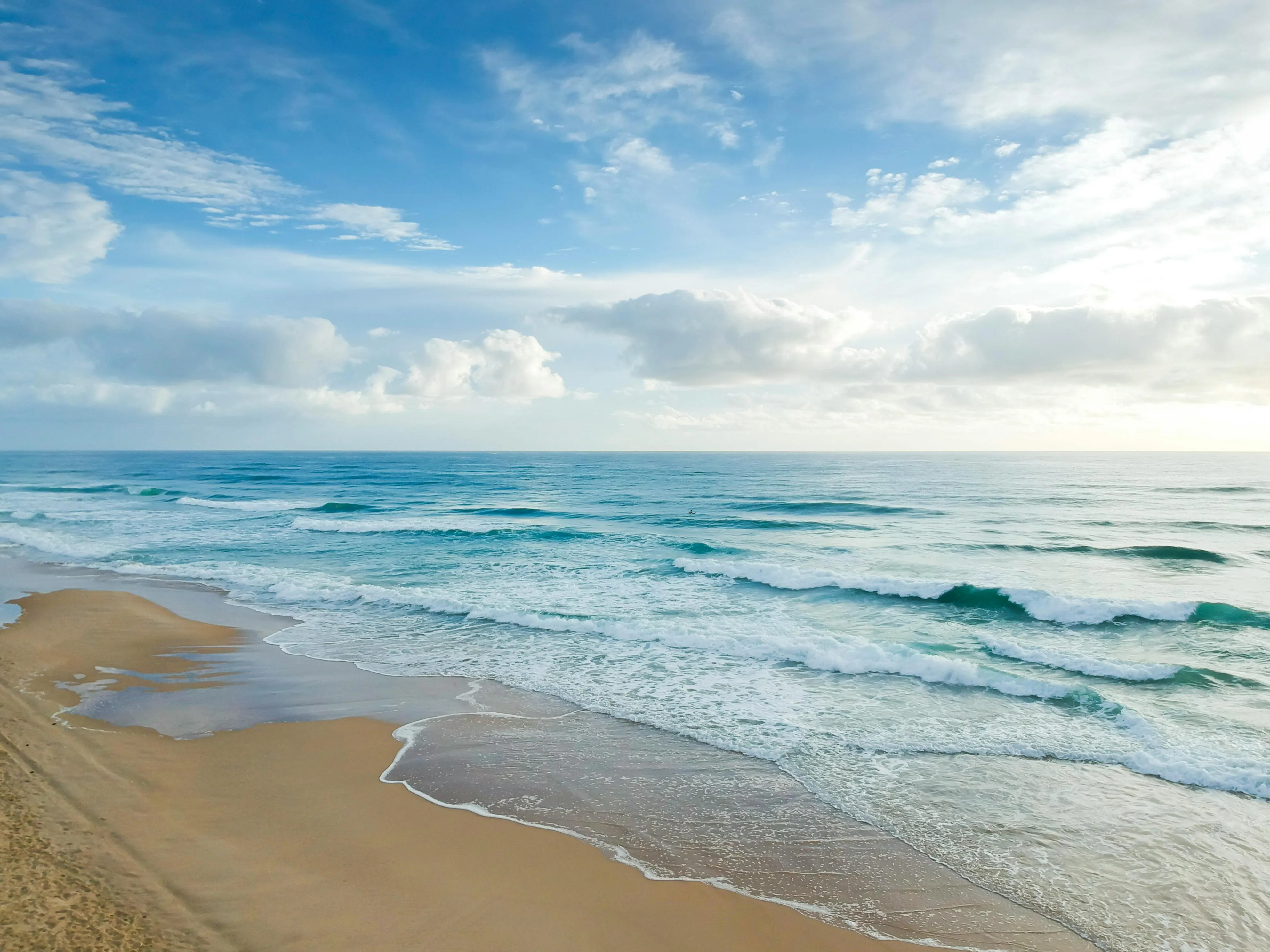 Peaceful Sandy Beach with Gentle Waves and Sky HD Wallpaper