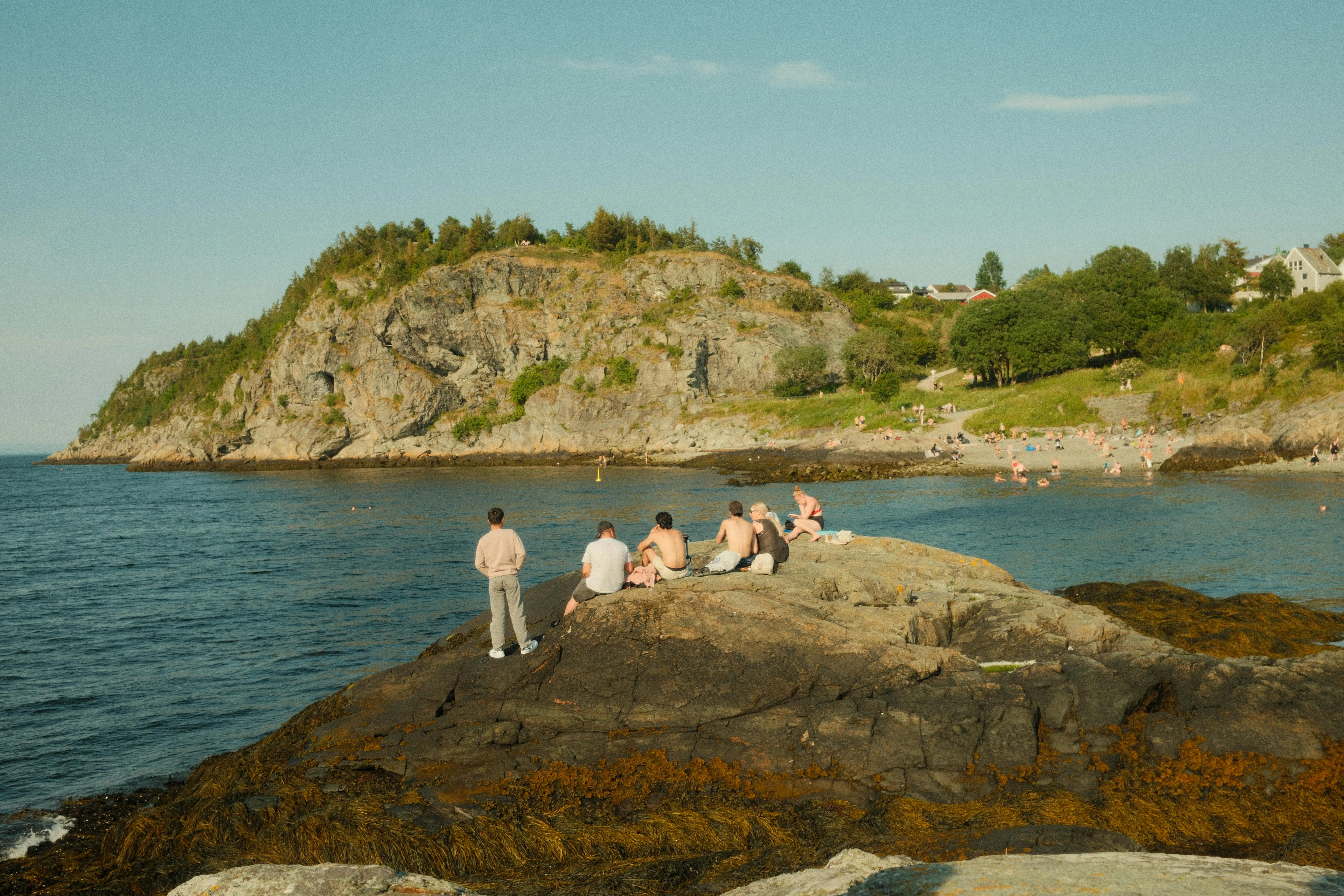 People Relaxing on the Rocky Beach Coast on a Sunny Day