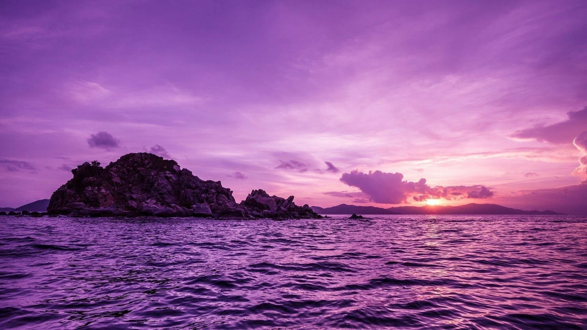 Purple Sky Sunset over the Ocean with Dark Rocky Shoreline