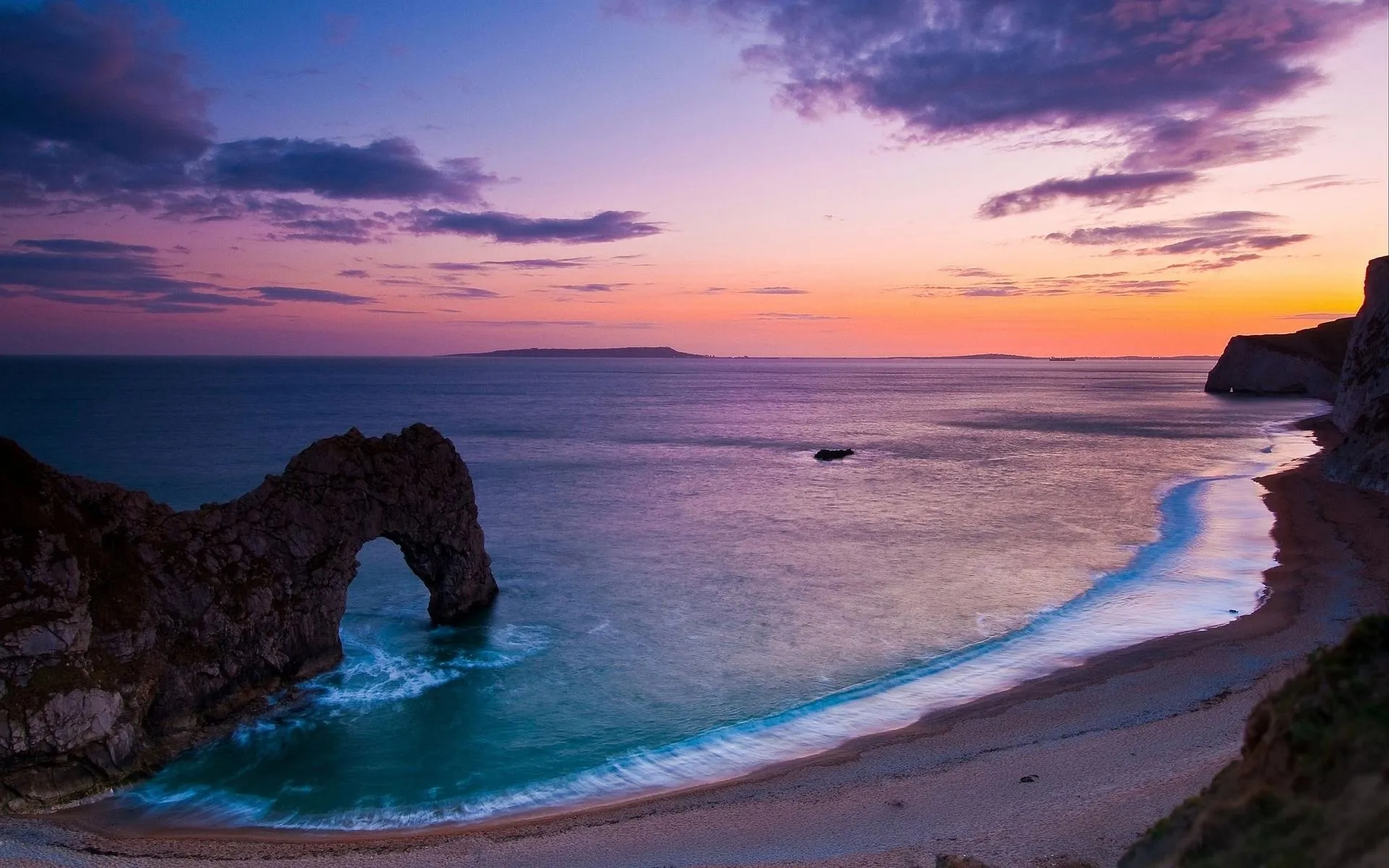 Purple Sunset Sky over the Ocean with a Rocky Arch