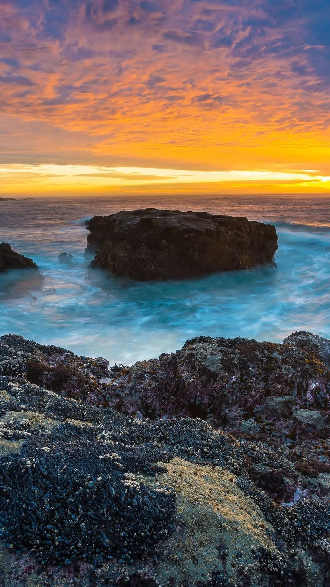 Rocky Beach Sunset Casting an Orange Glow in the Ocean Waves