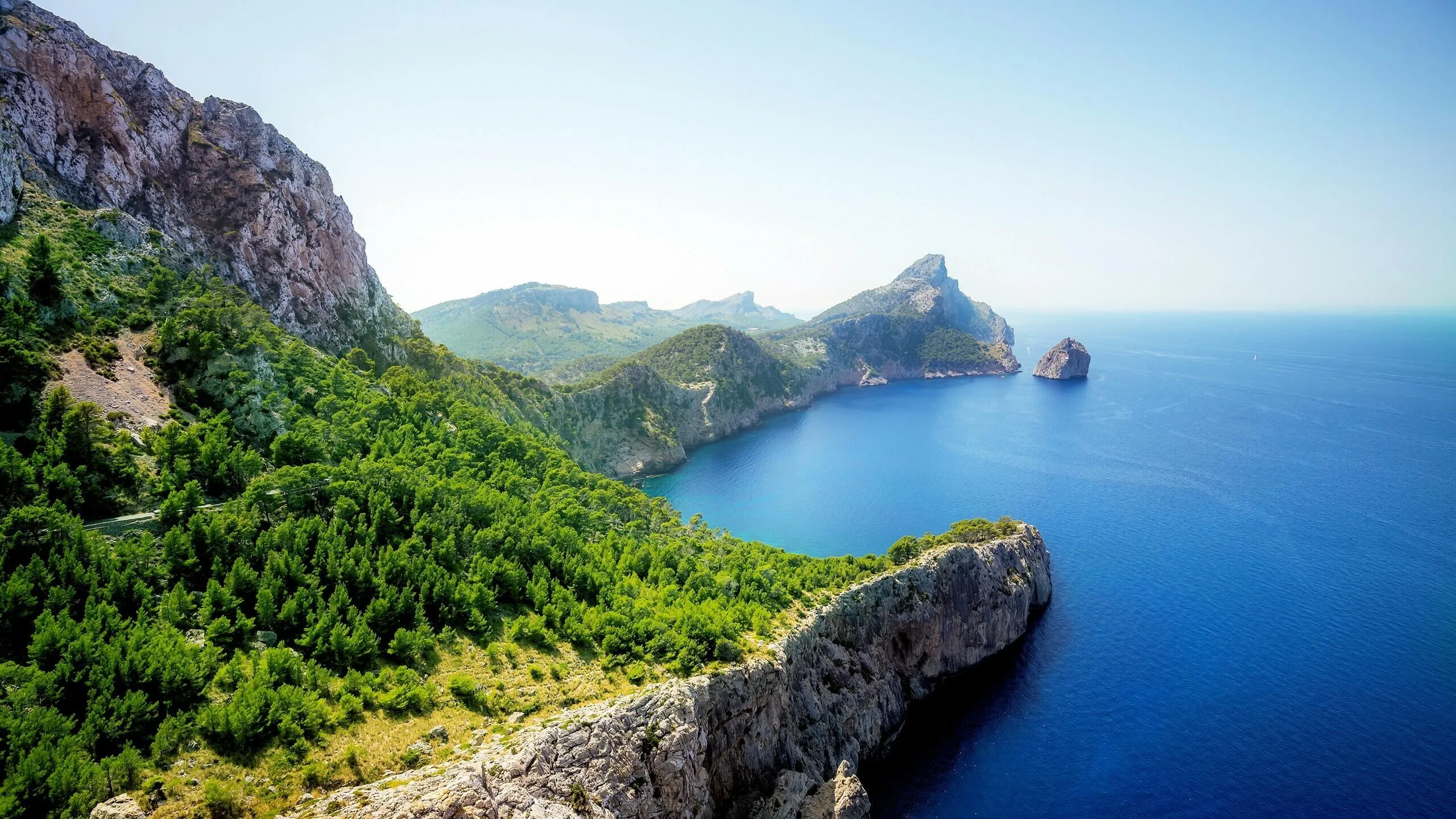 Rocky Green Island Cliffs Above Bright Tropical Ocean