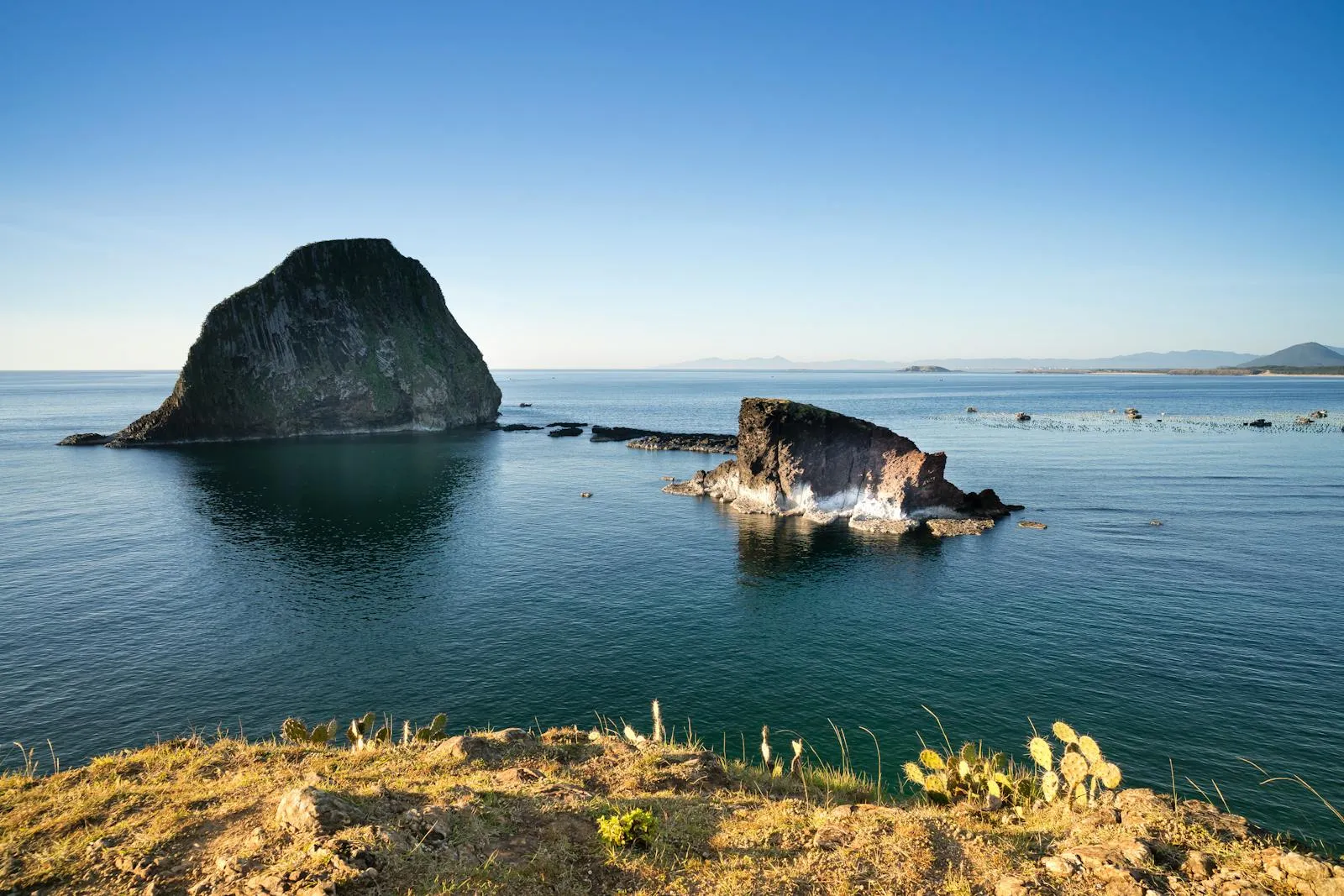 Rocky Island Formations Under a Clear Blue Sky Wallpaper