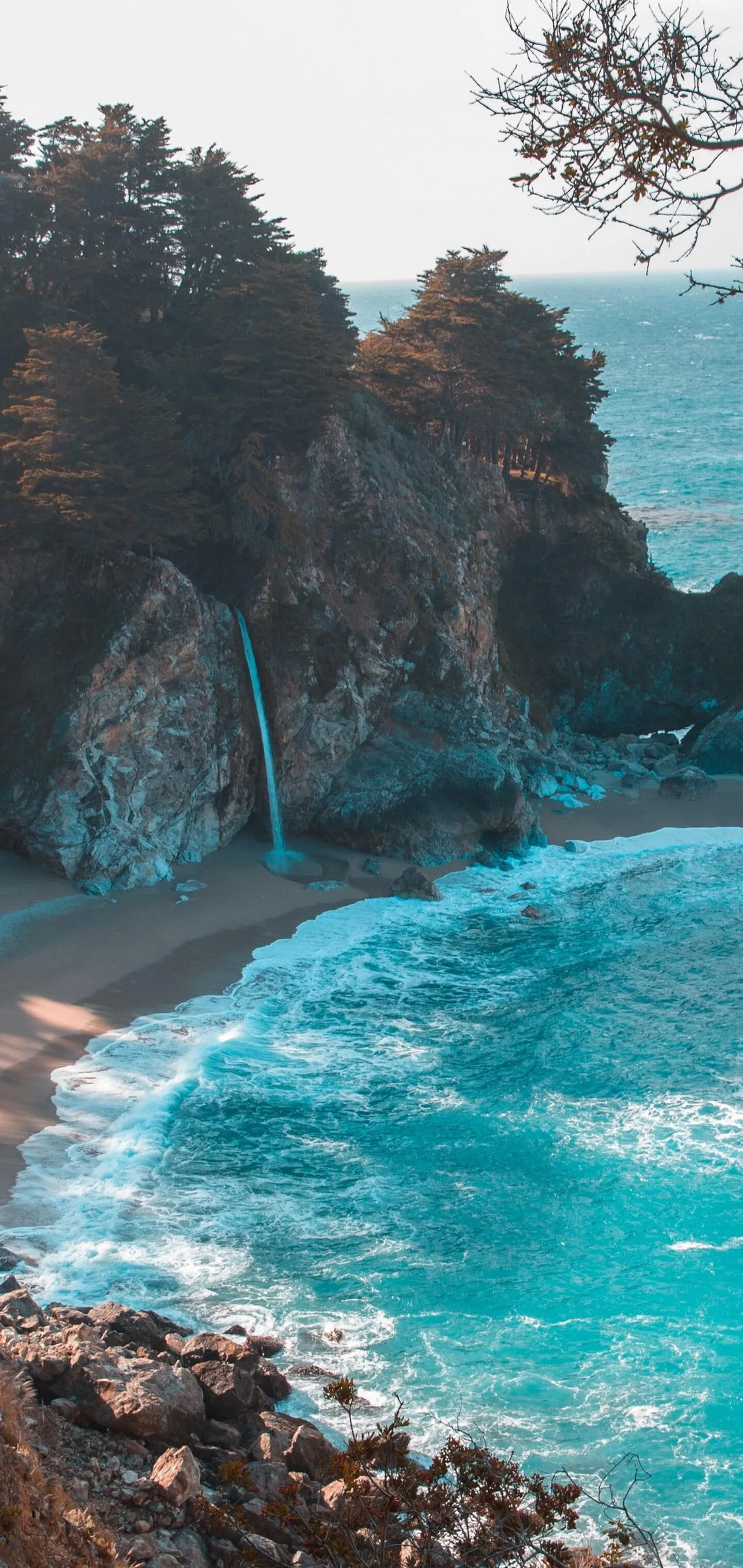 Rugged Cliffside Beach with Teal Ocean and Rock Formations