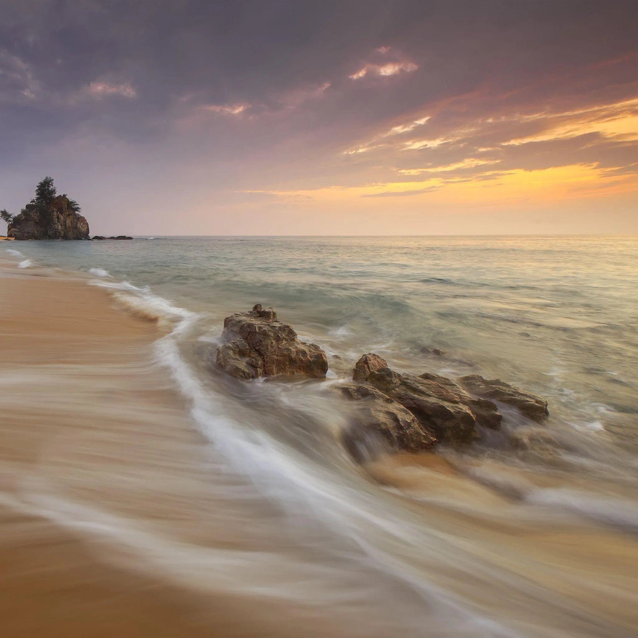 Sandy Beach with Gentle Waves at a Beautiful Sunset