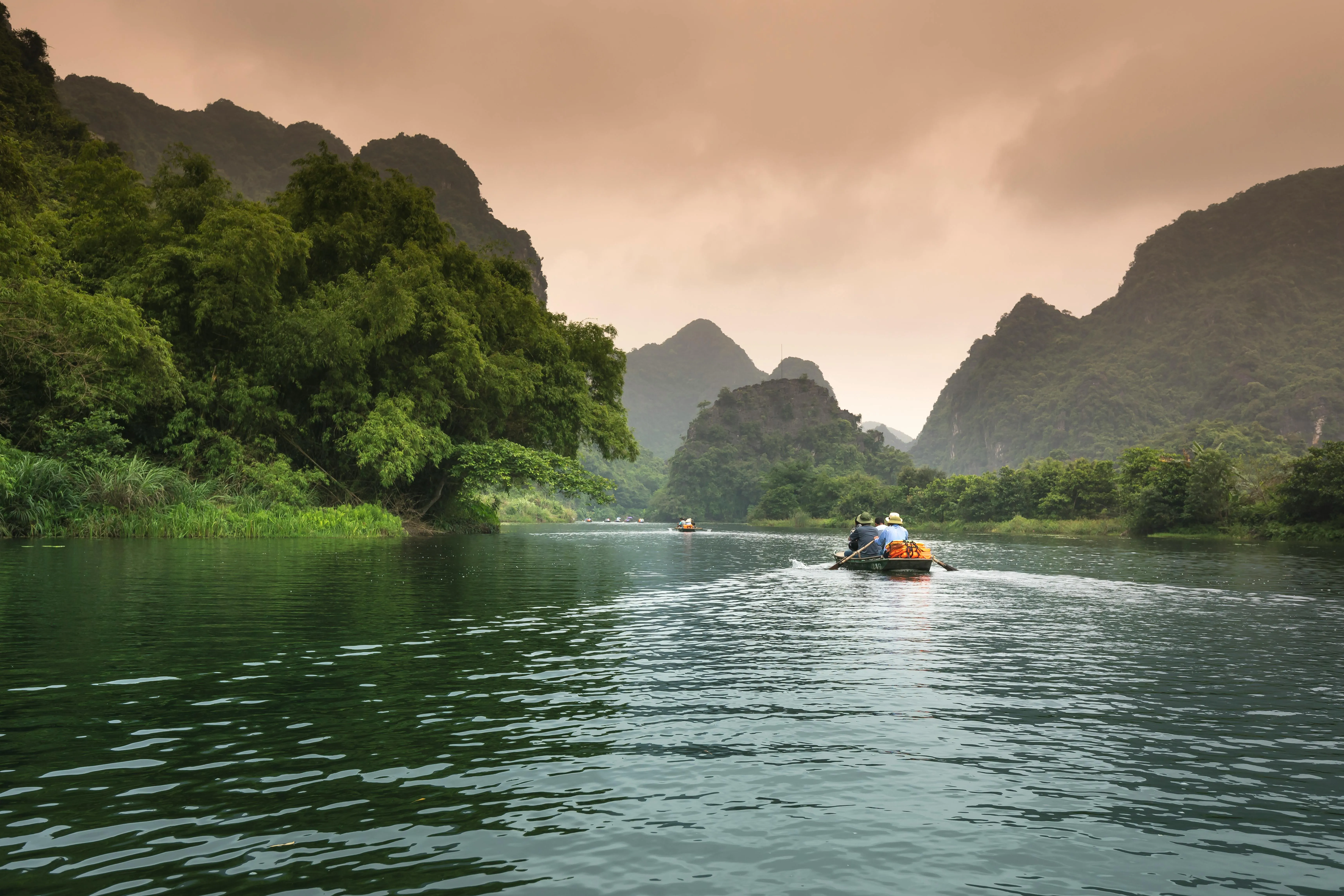 Small Boat Floating Through a Green Mountain Lake Valley
