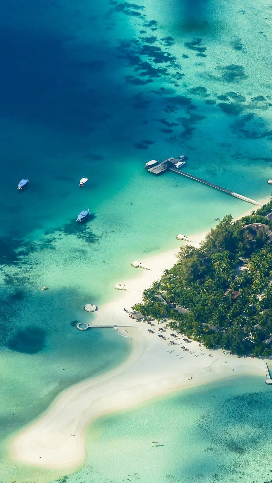 Small Island with Sandy Beaches and Boats on Clear Water