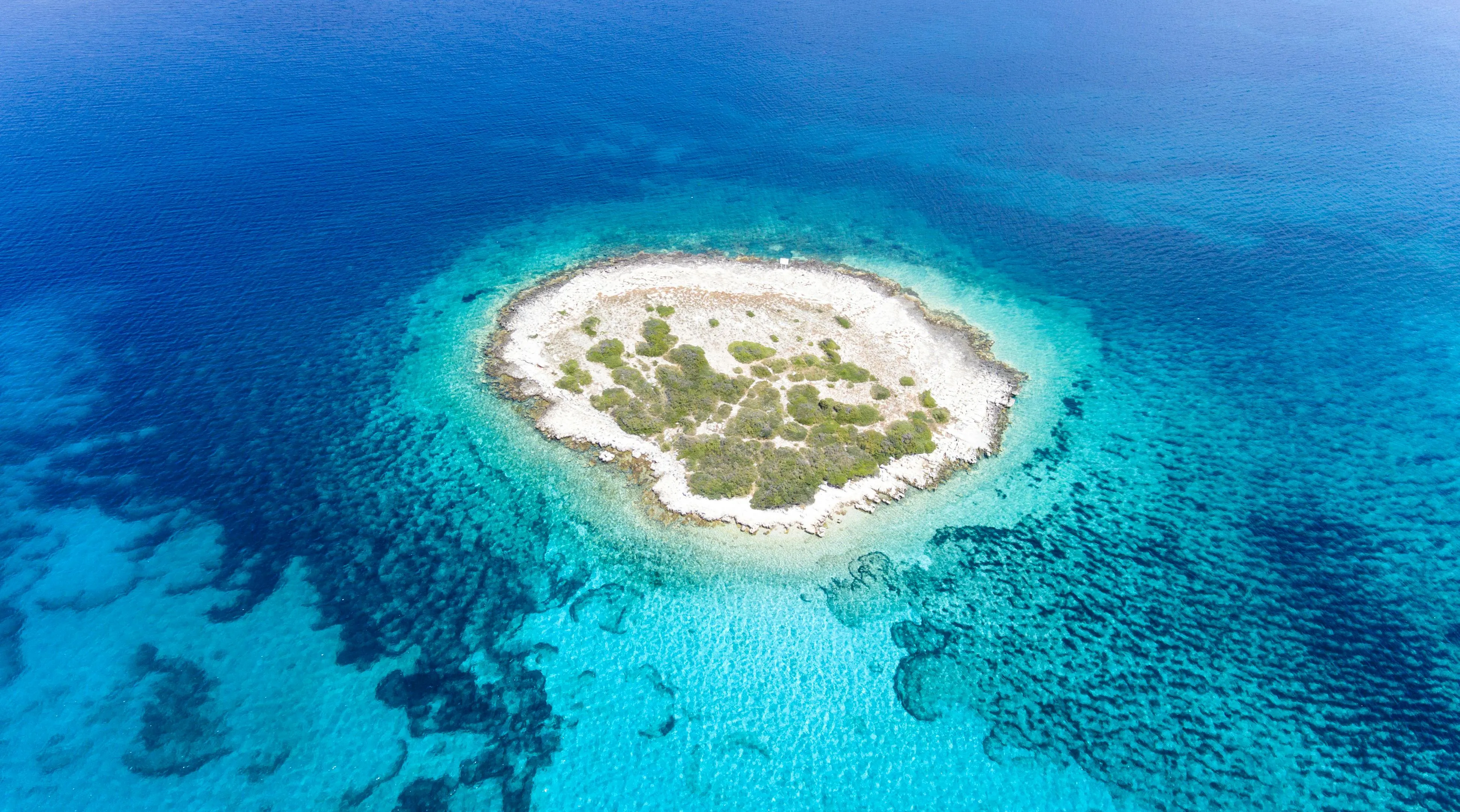 Small Island Surrounded by Bright Blue Shallow Water