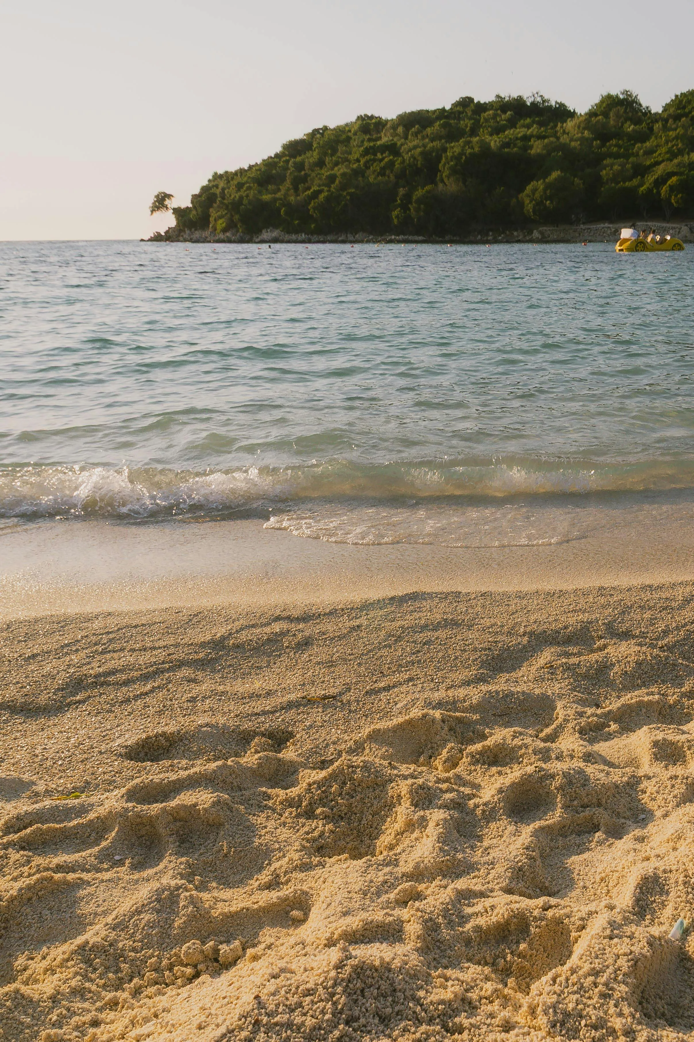 Soft Sand Beach with Gentle Sea Waves at Sunset Wallpaper