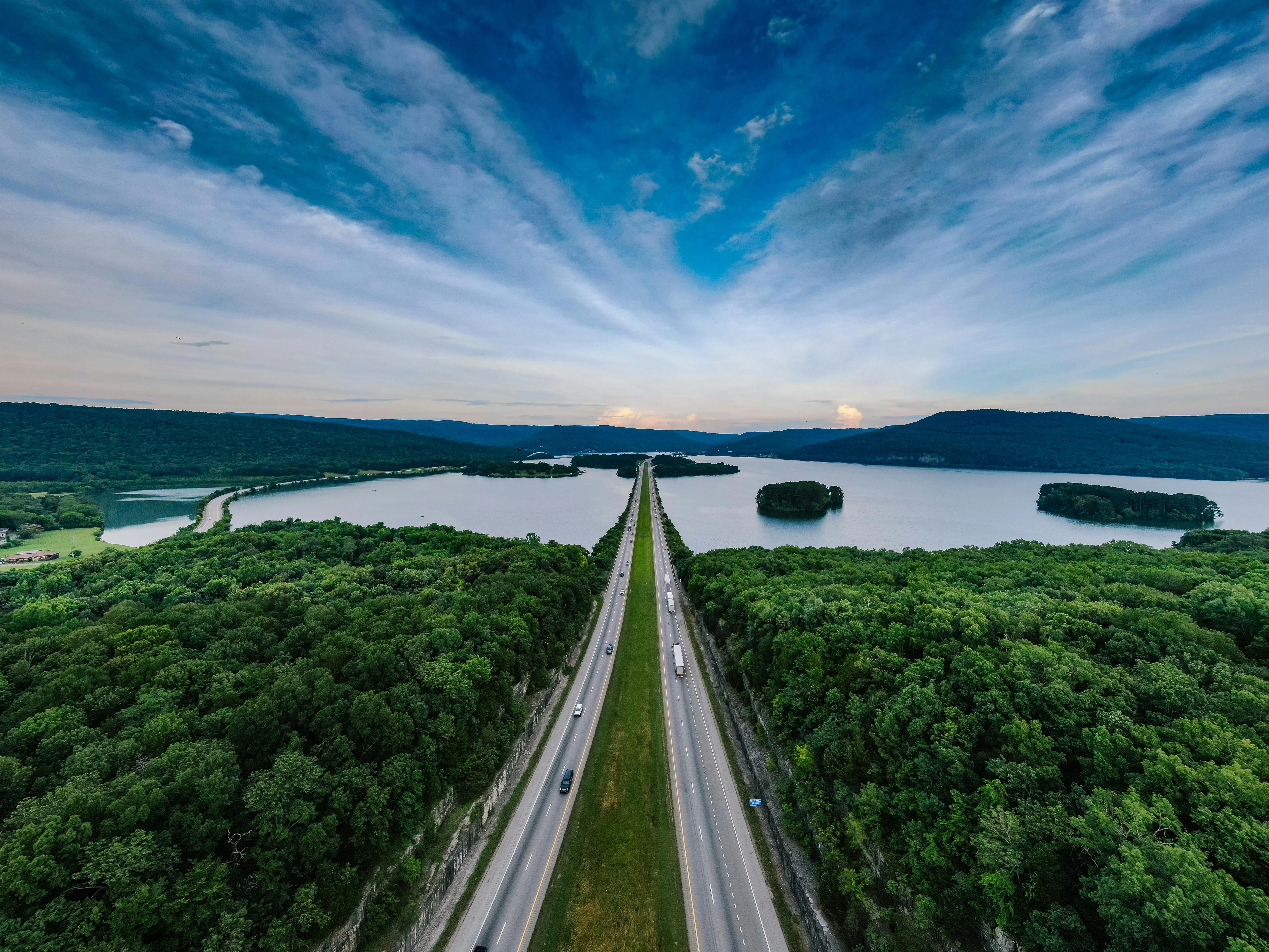Straight Road Stretching Through a Lake and a Forest View