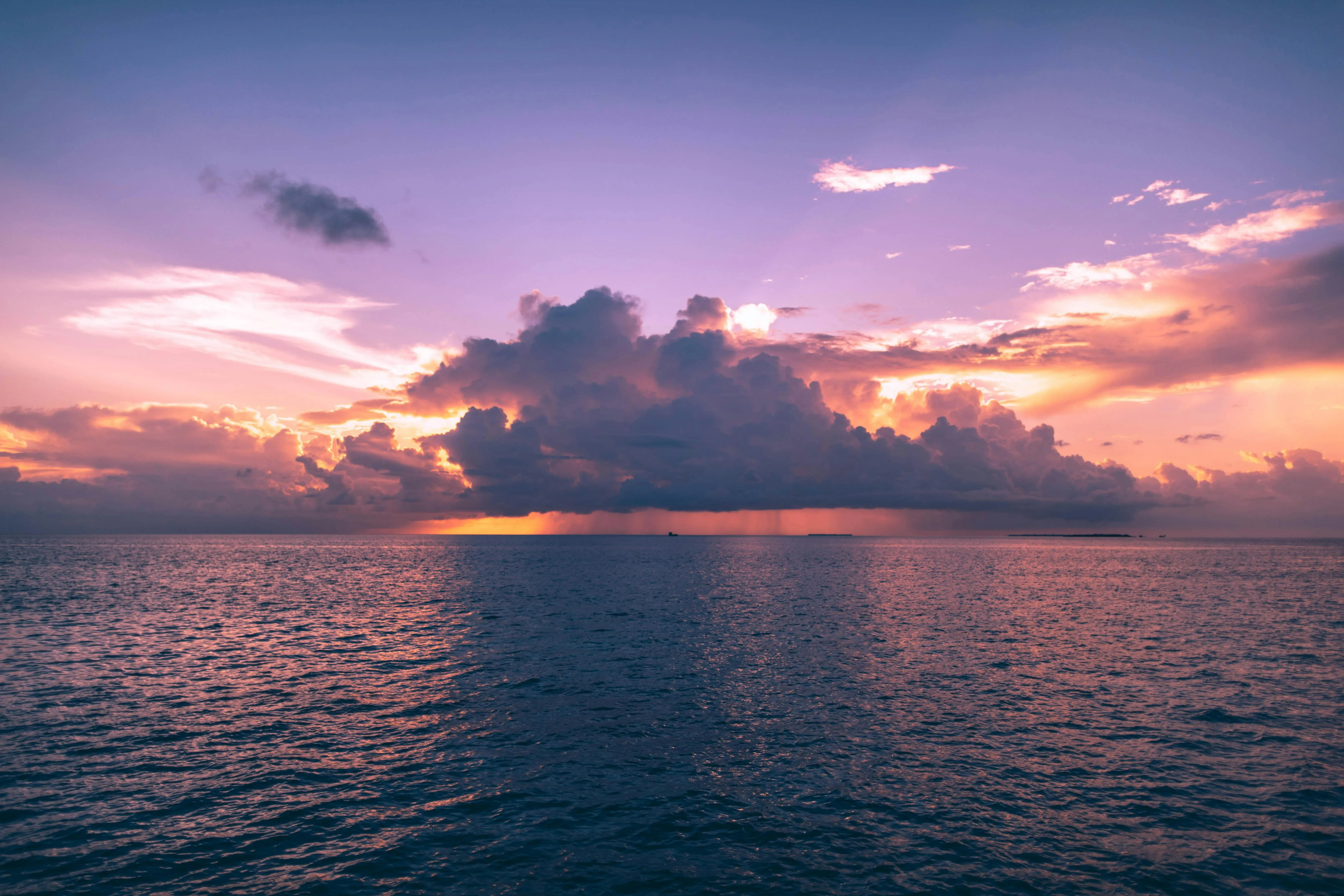 Stunning Sunset over the Ocean with Clouds and Calm Waves