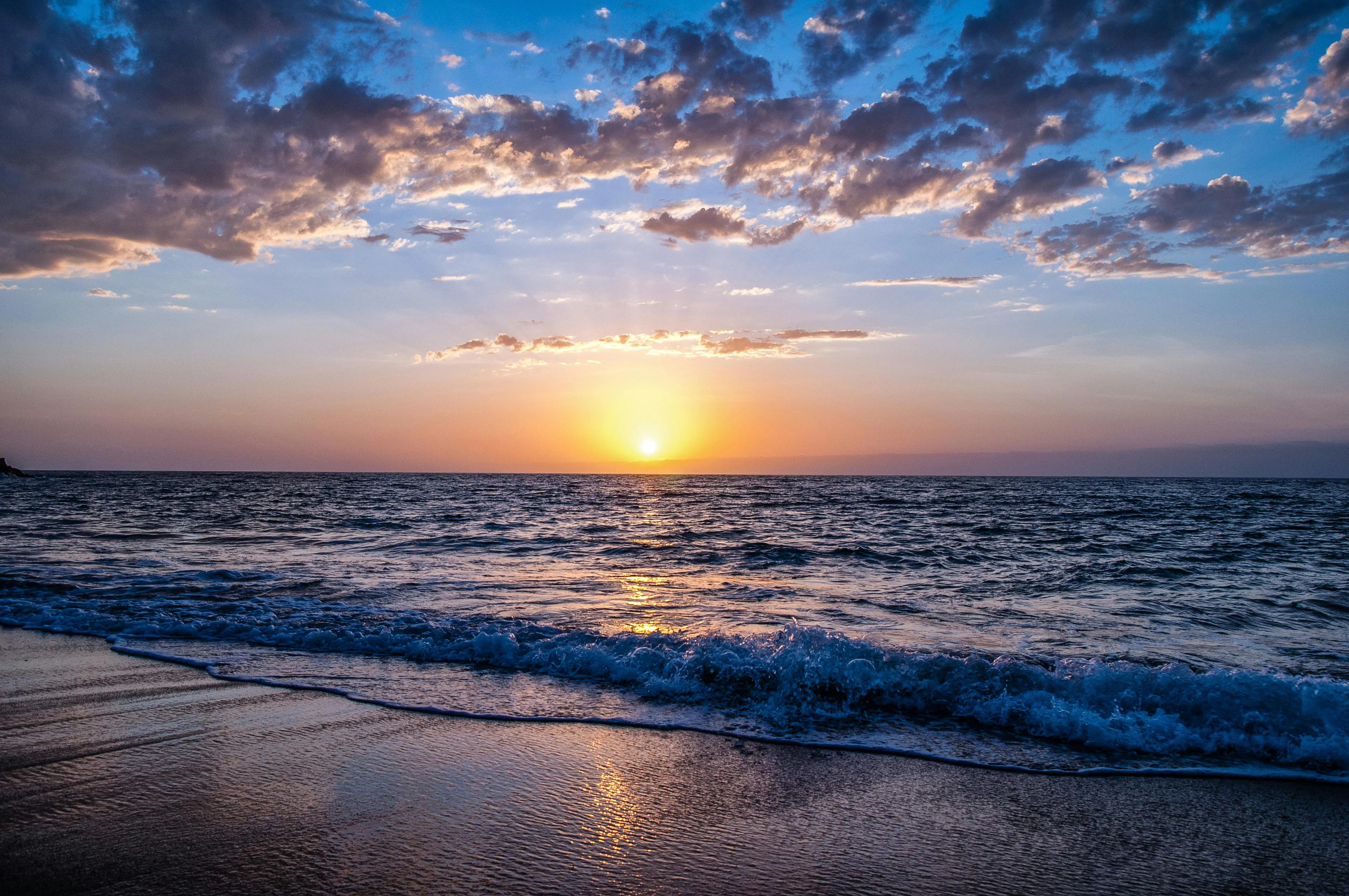 Sunset with Colorful Sky over Calm Ocean and Sandy Beach