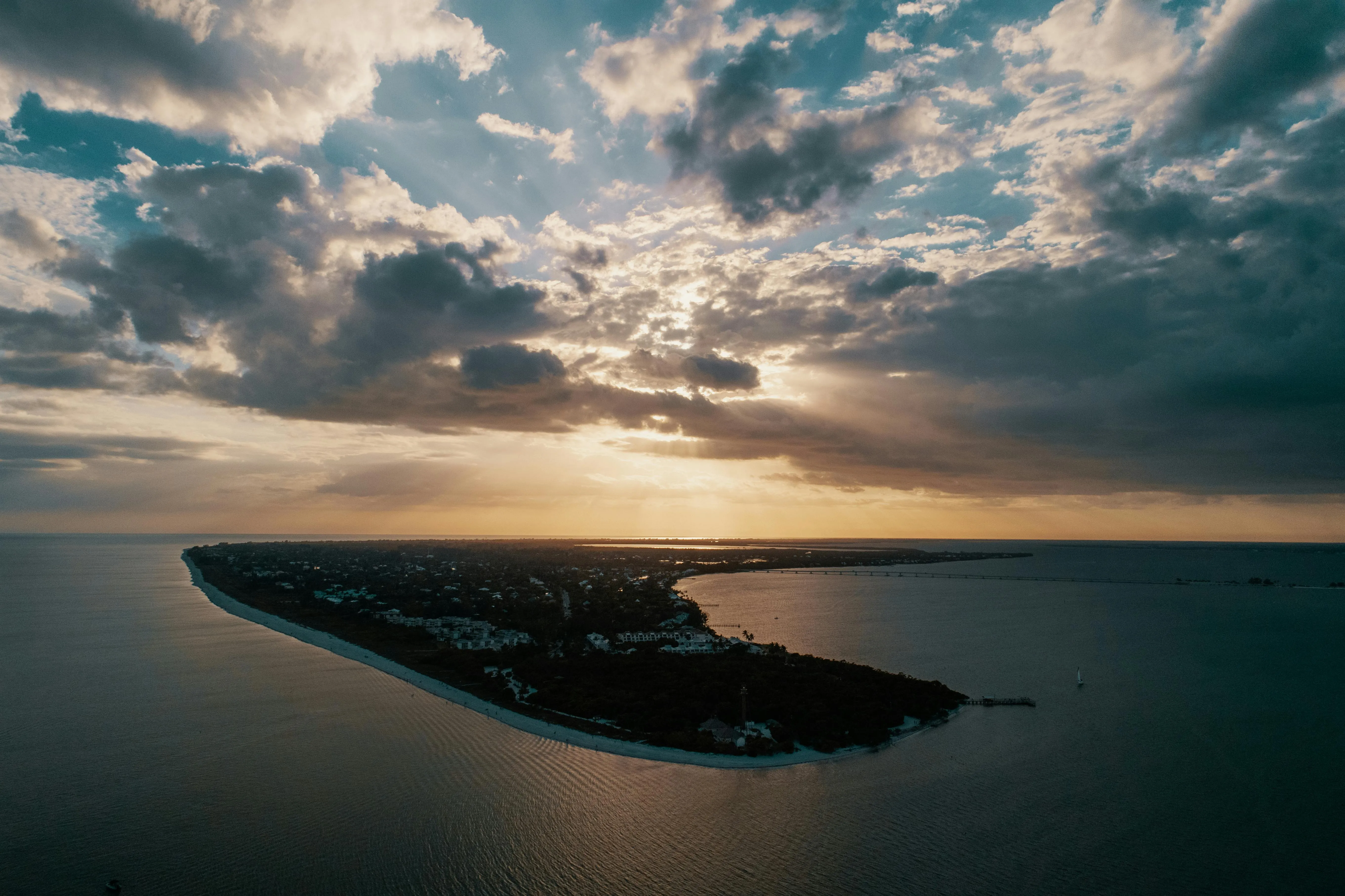 Sunset over a Narrow Island with Dramatic Clouds Wallpaper