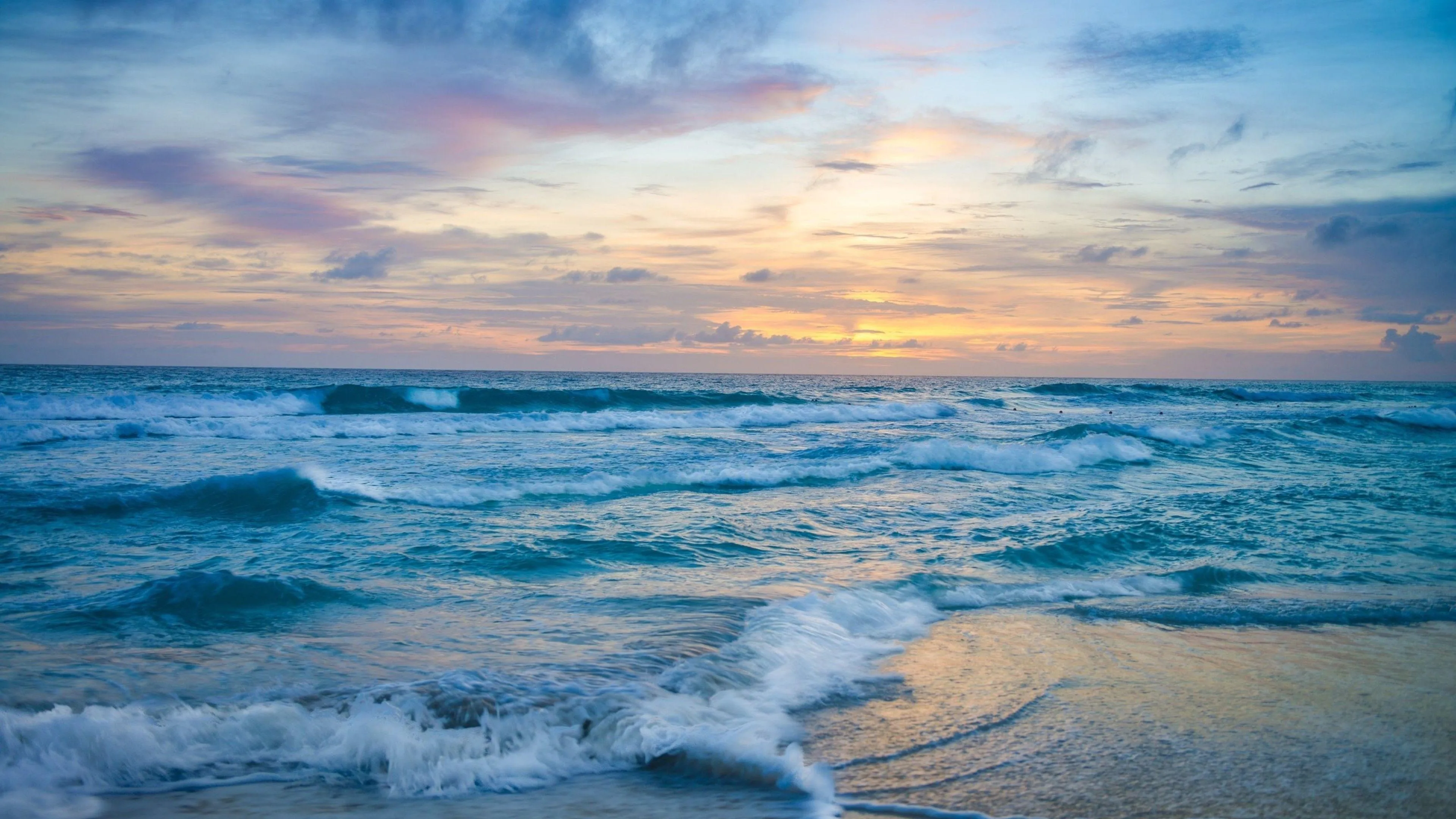 Sunset over Ocean Waves with Soft Colorful Sky Reflections