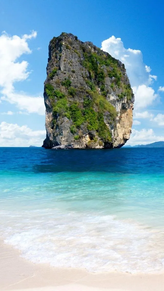 Tall Rock Island Rising from the Turquoise Sea Wallpaper
