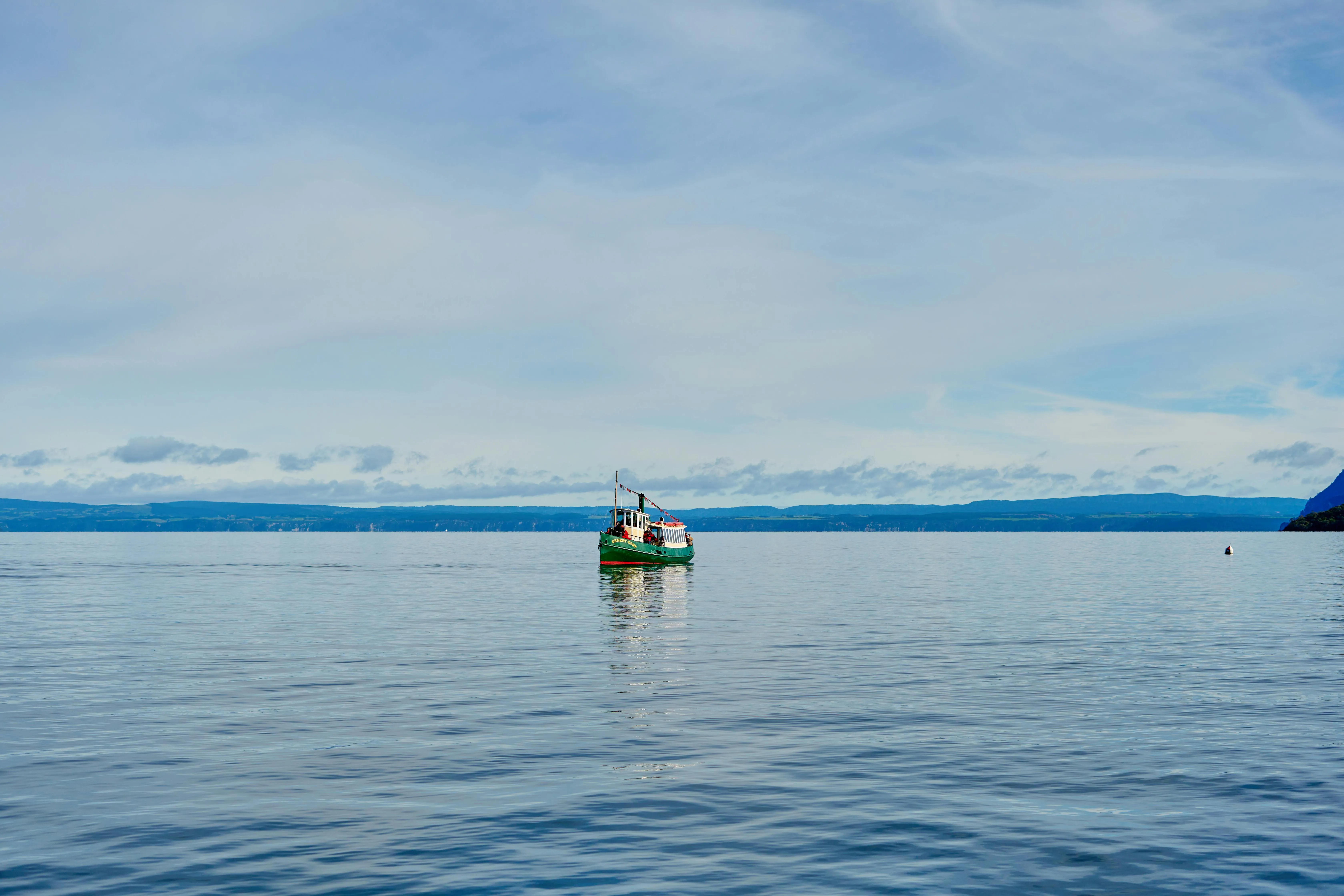 Tiny Fishing Boat Floating in the Middle of the Ocean
