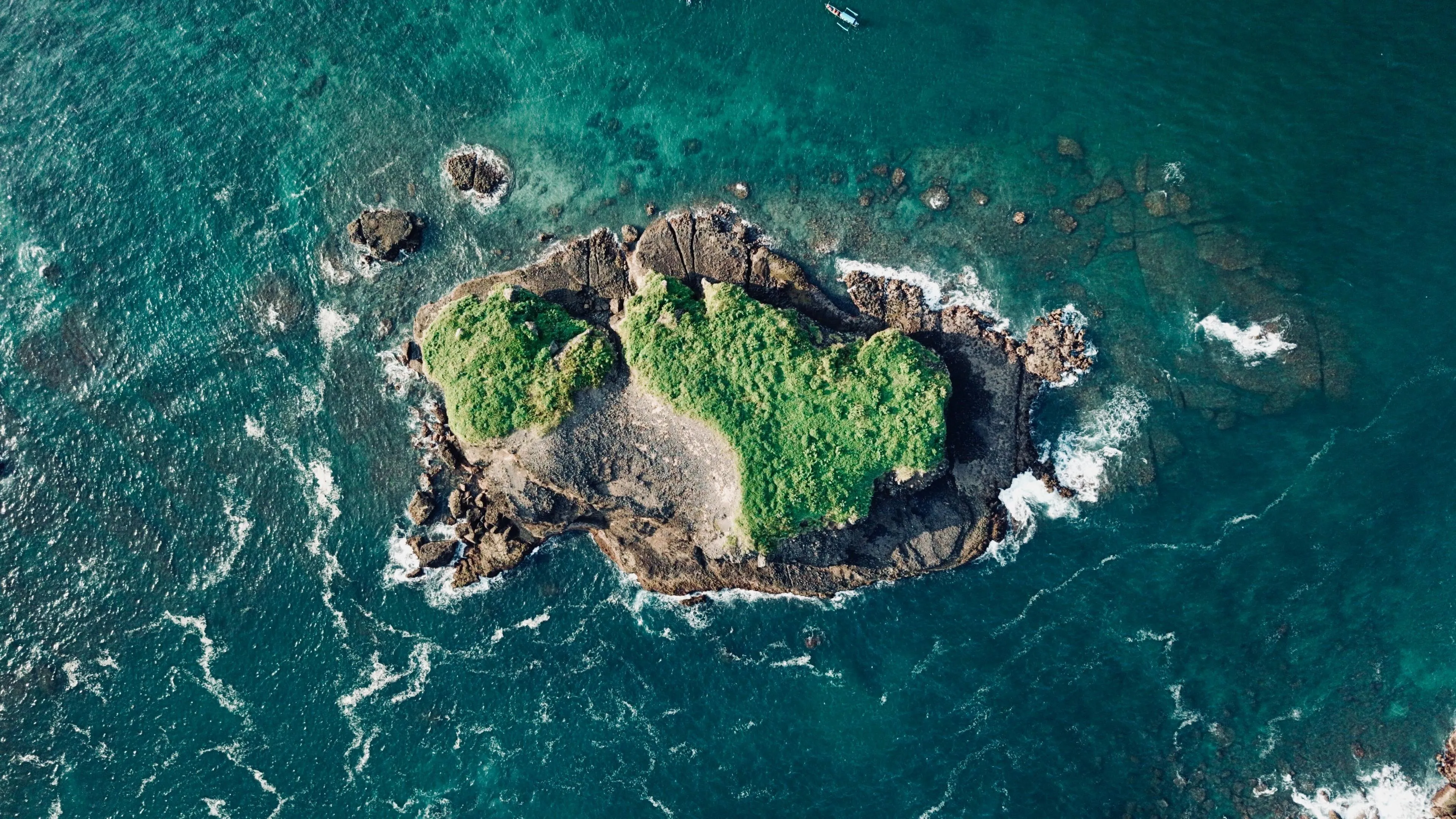 Top View of a Green Island with a Sharp Rocky Coastline