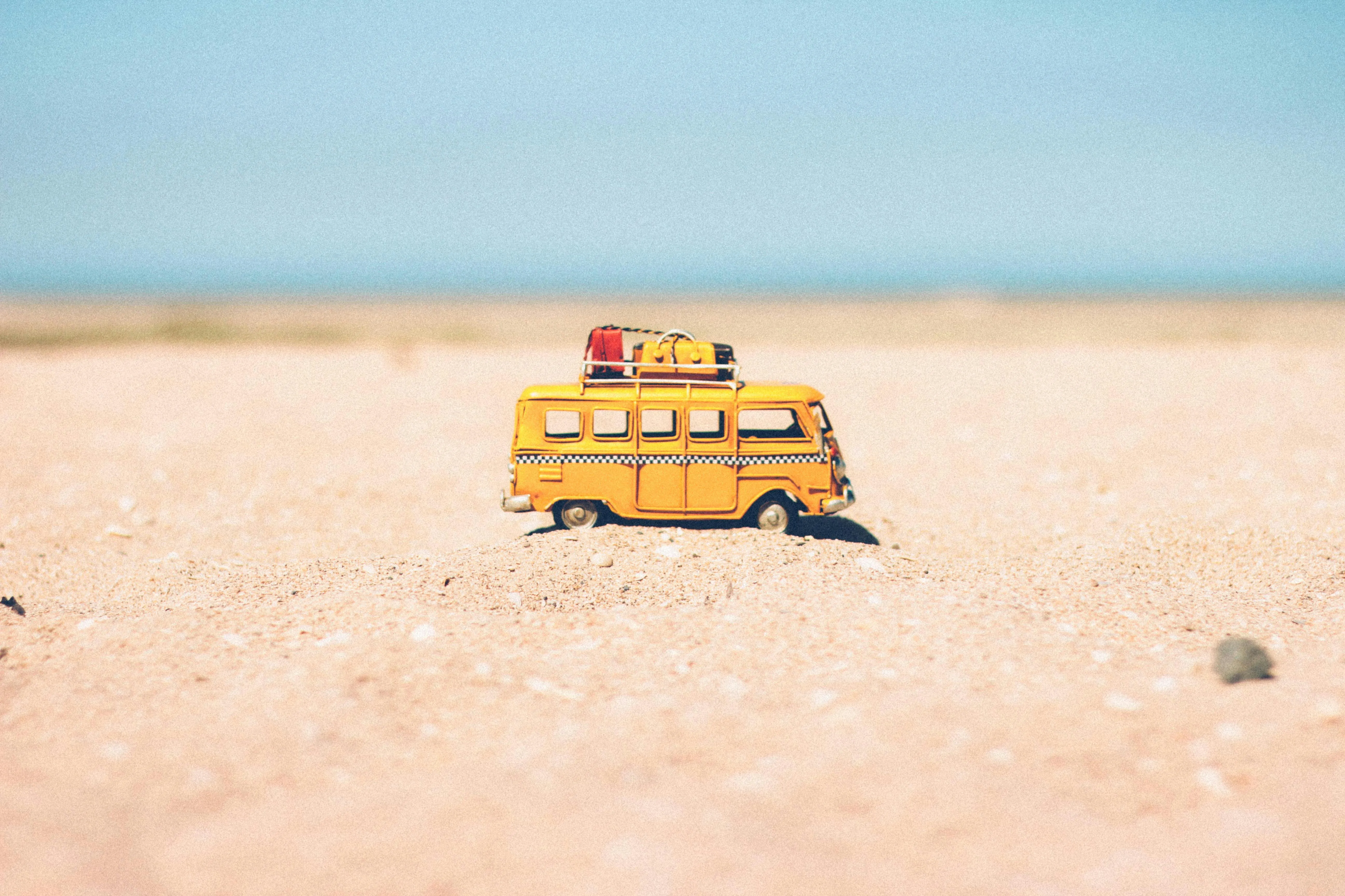 Toy Van on Sandy Beach Under Blue Sky with Holiday Vibe