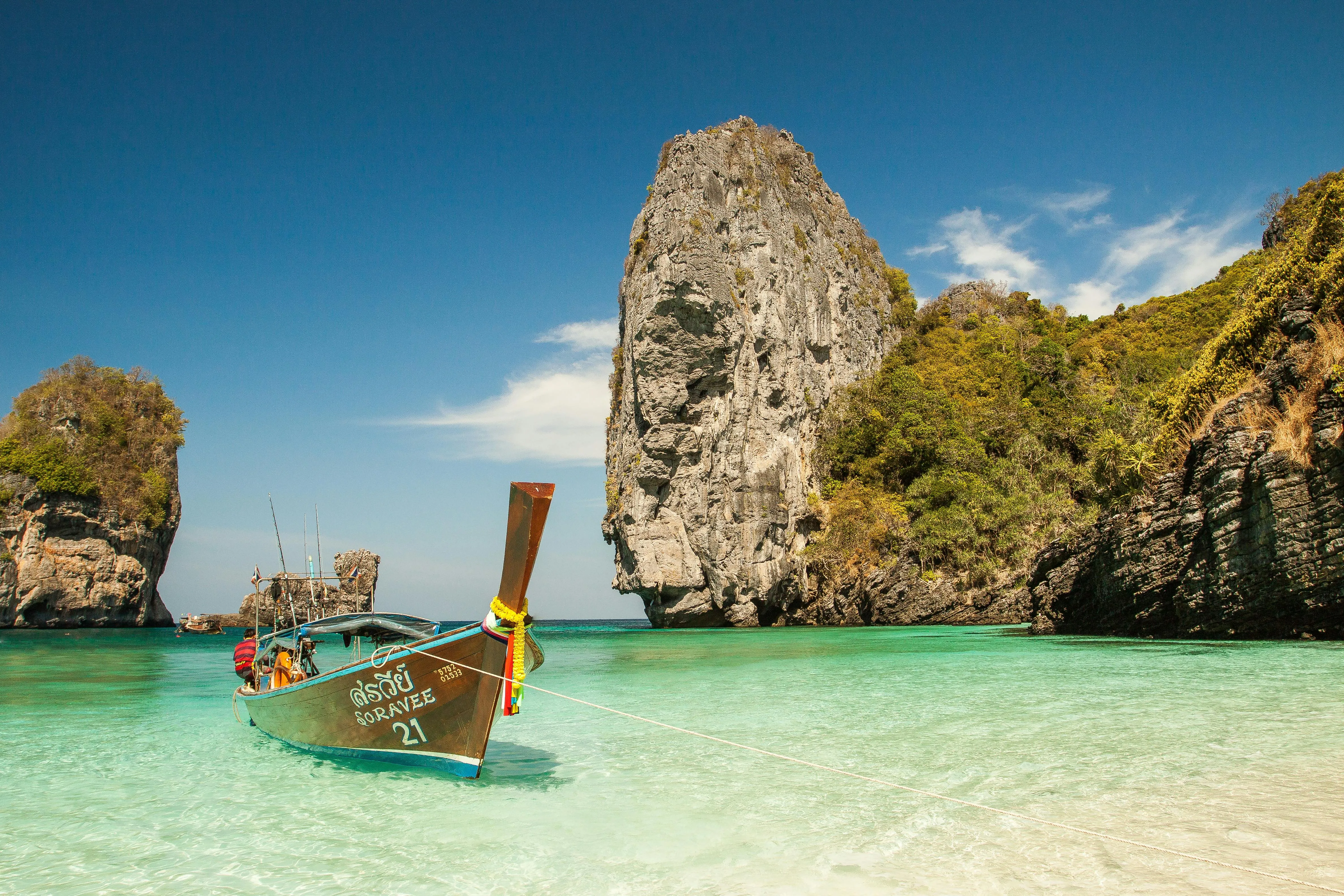 Traditional Boat Floating in Turquoise Water Near Cliffs