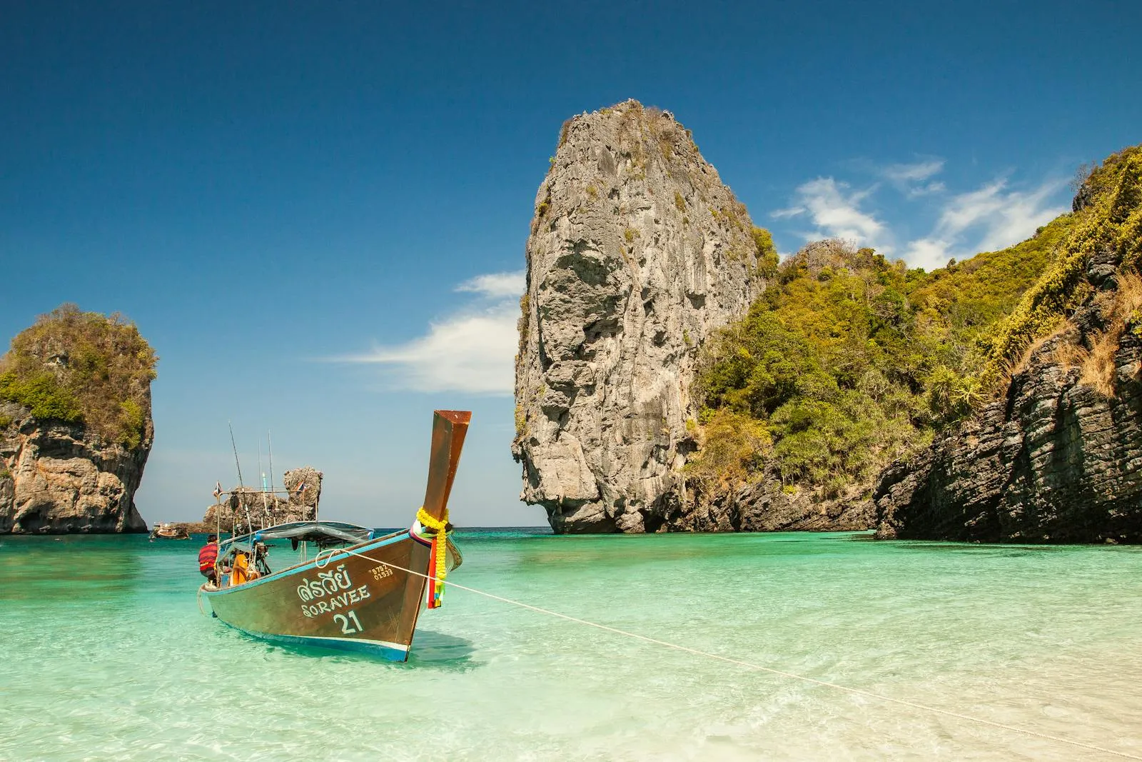 Traditional Boat Near Sharp Rock in Clear Water HD Wallpaper