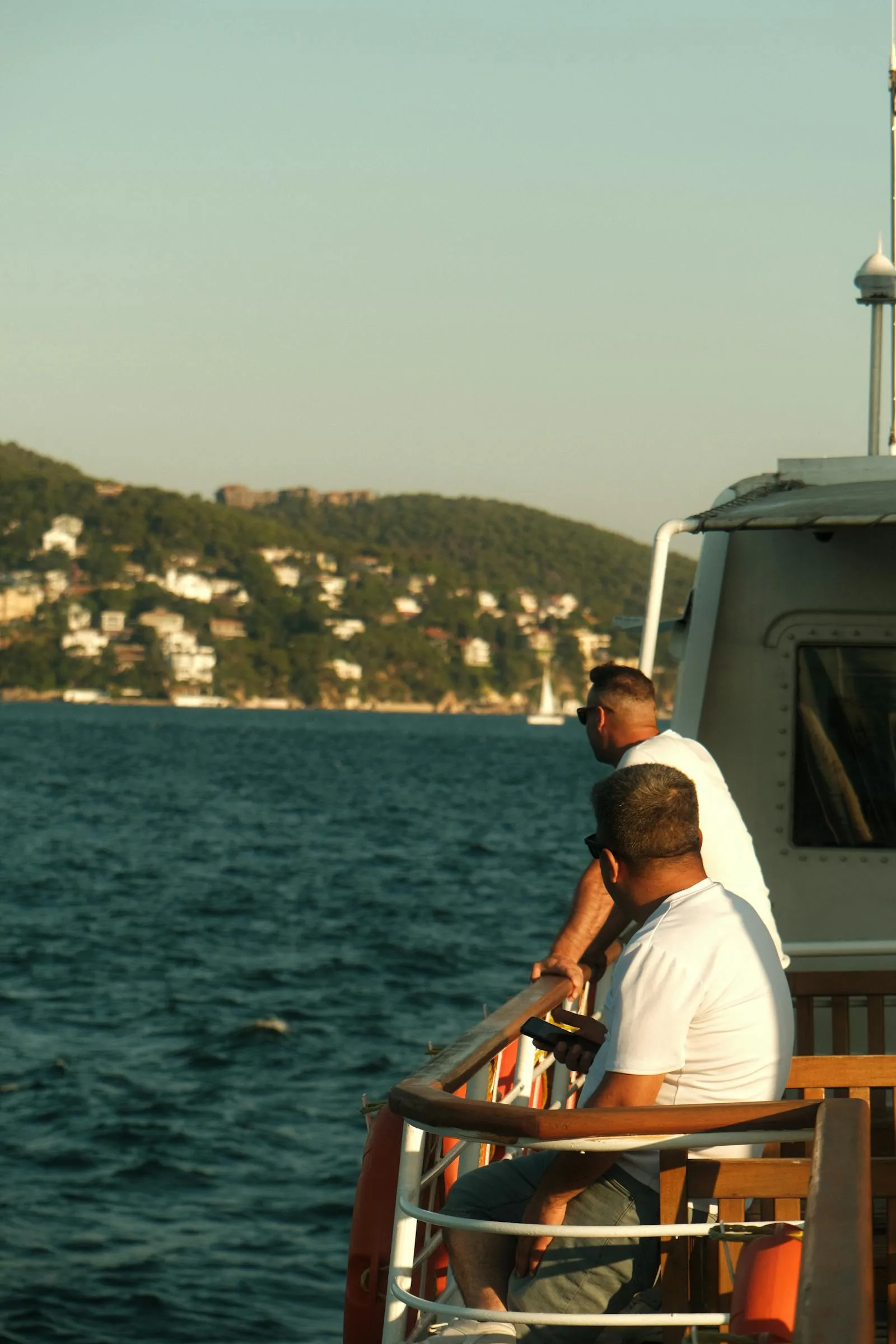 Two Men are Relaxing on a Boat in the Ocean Free Wallpaper