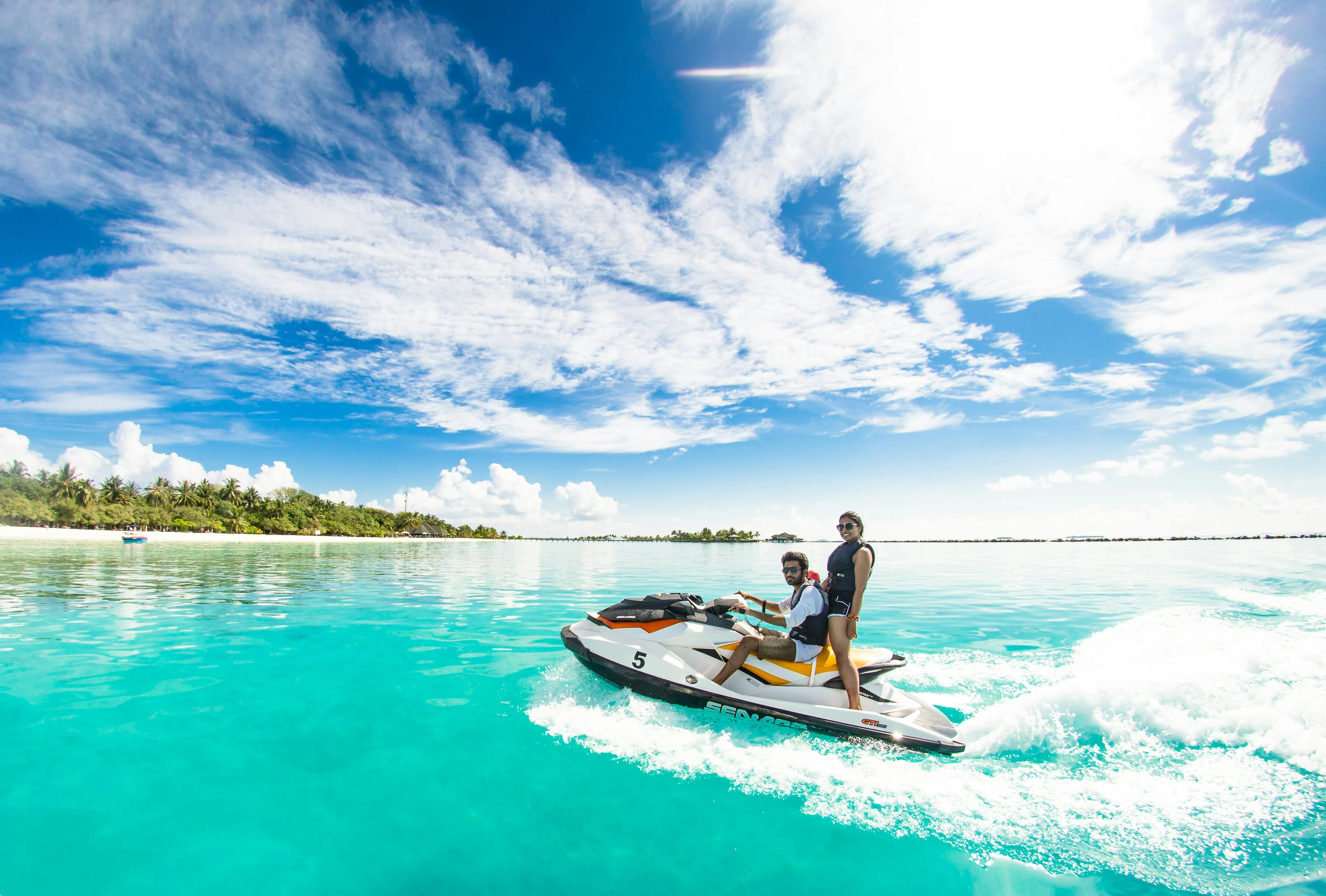 Two People Riding a Dinghy on Bright Sunny Ocean Waves
