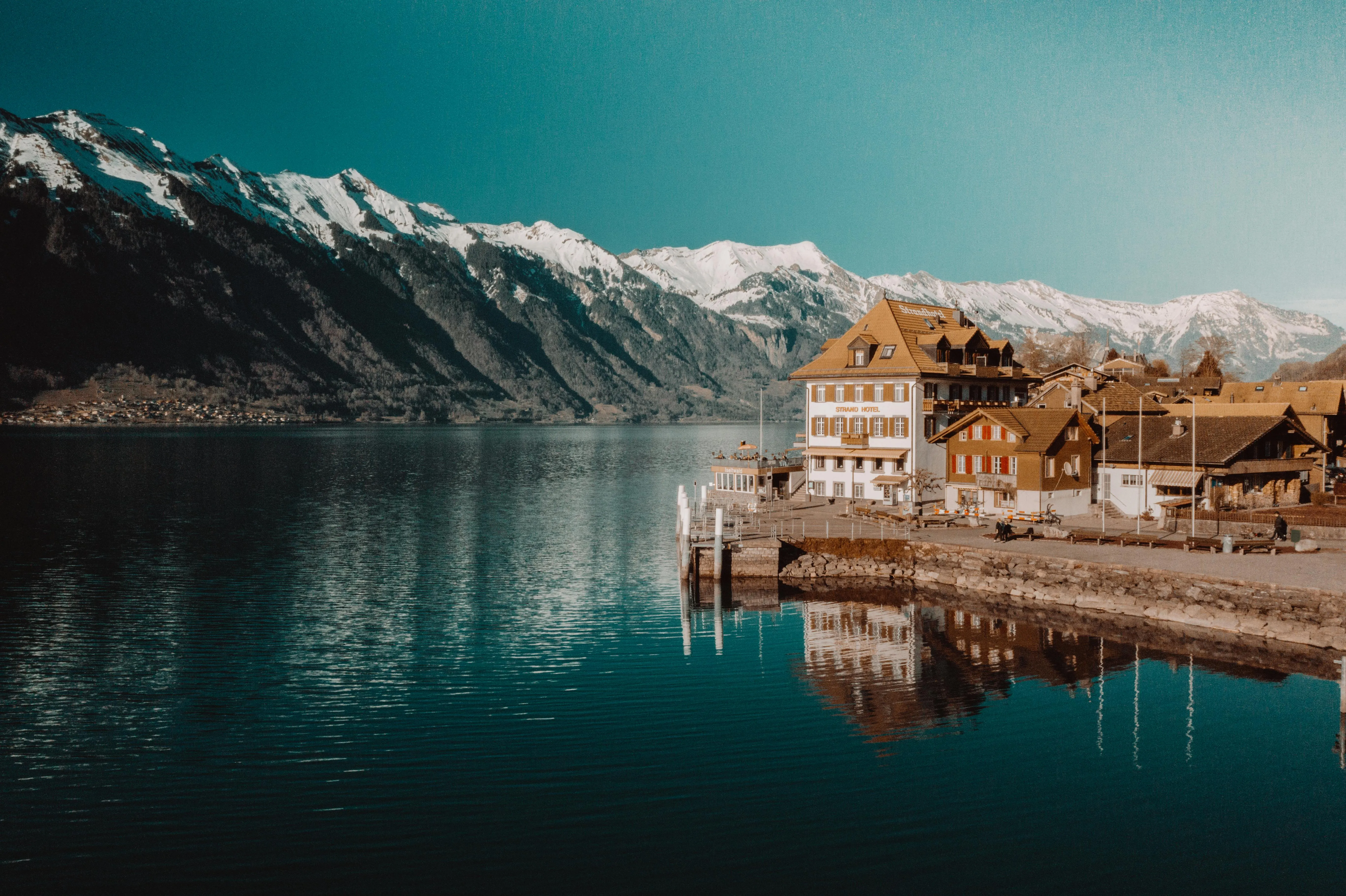 Village by a Lake with Snowy Mountains
