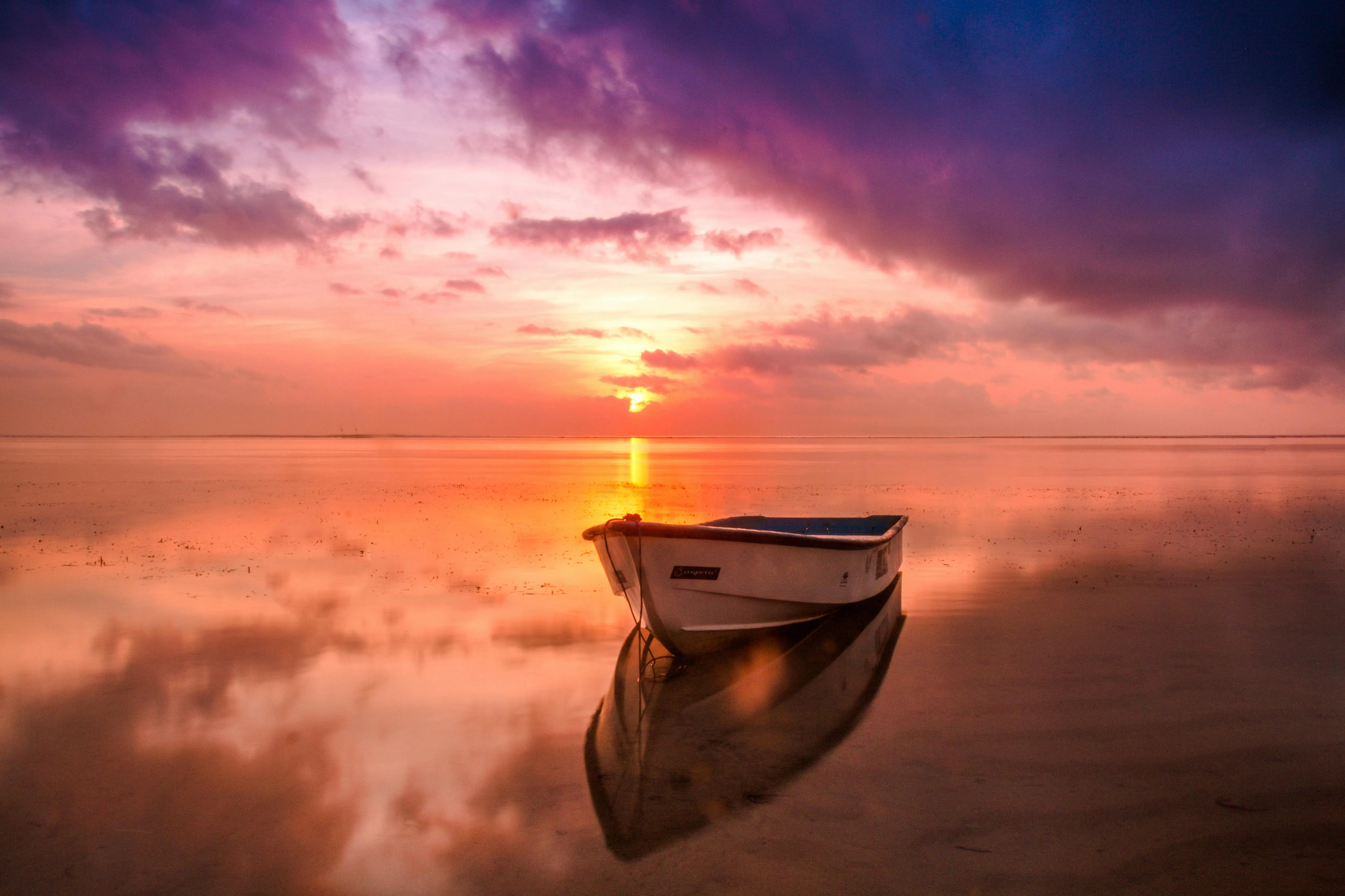 Wooden Boat Floating on Calm Water During Purple Sunset