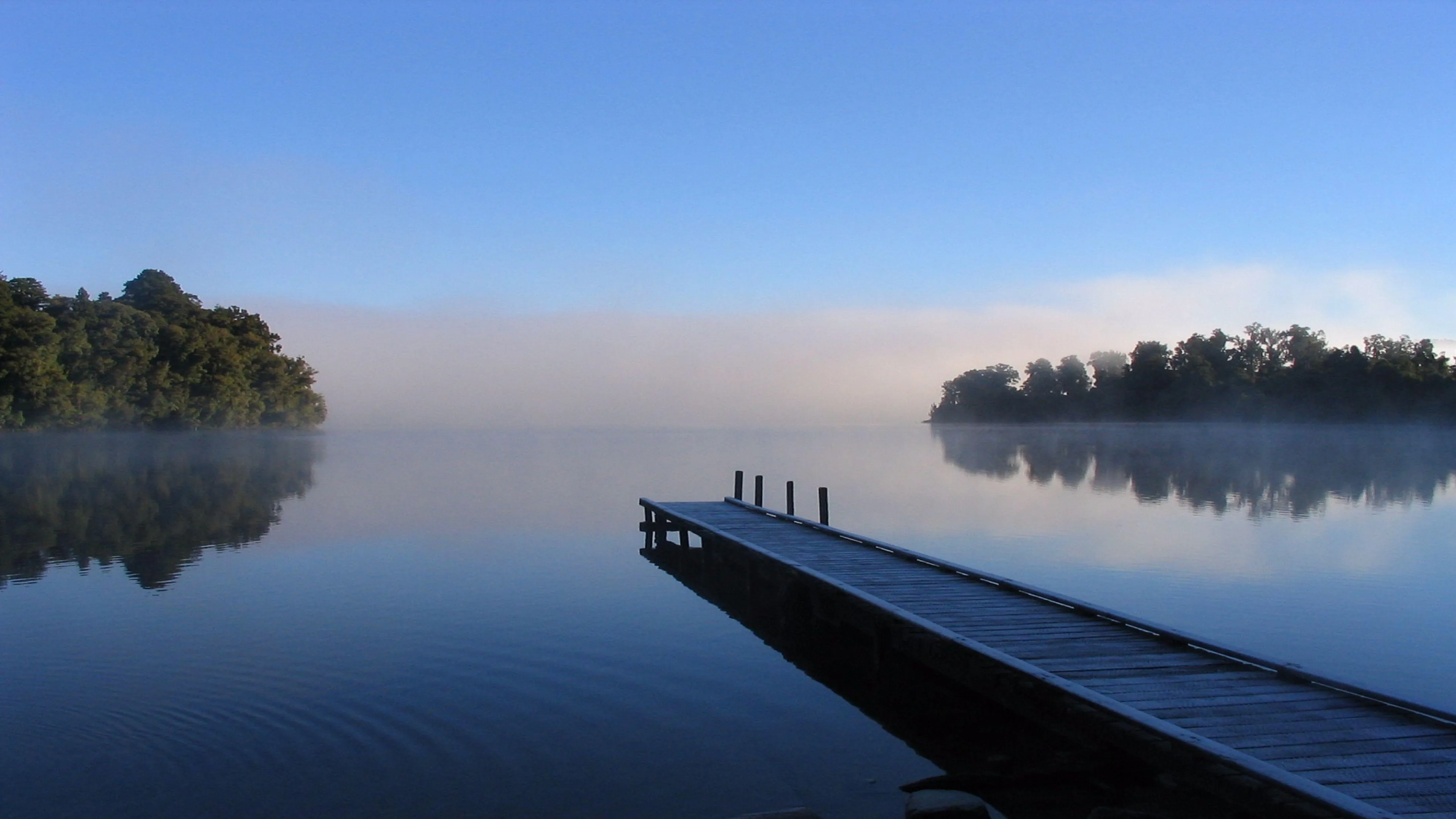 Wooden Dock on Quiet Lake During Sunset Reflection Wallpaper