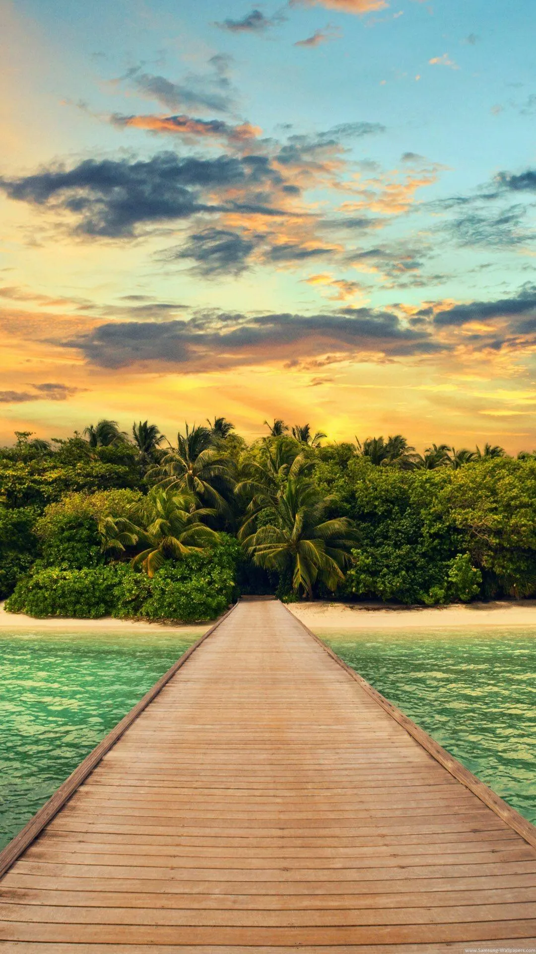 Wooden Walkway Leading Through Green Palm Trees to the Beach