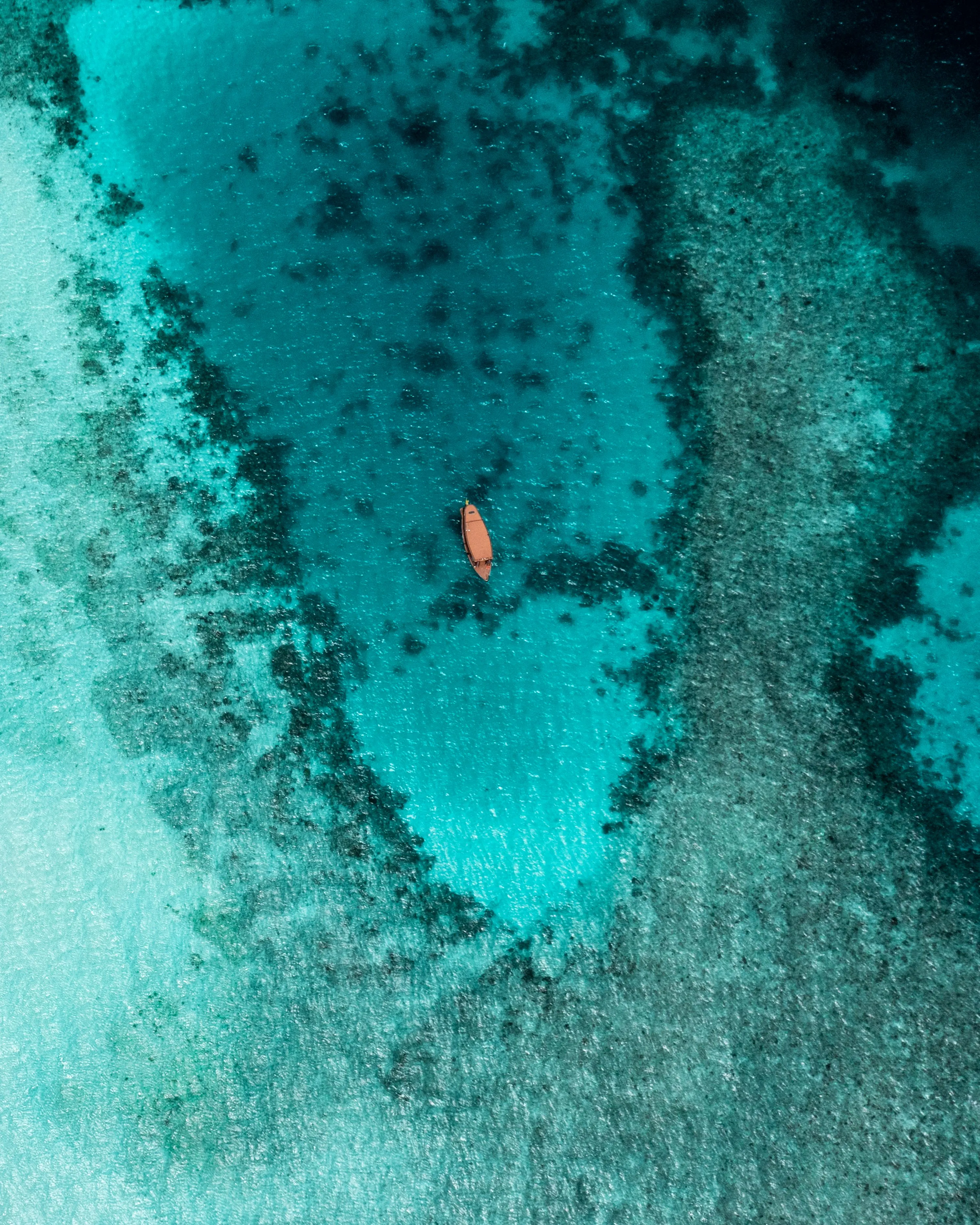 Aerial View of Clear Blue Ocean and Coral Reefs Wallpaper