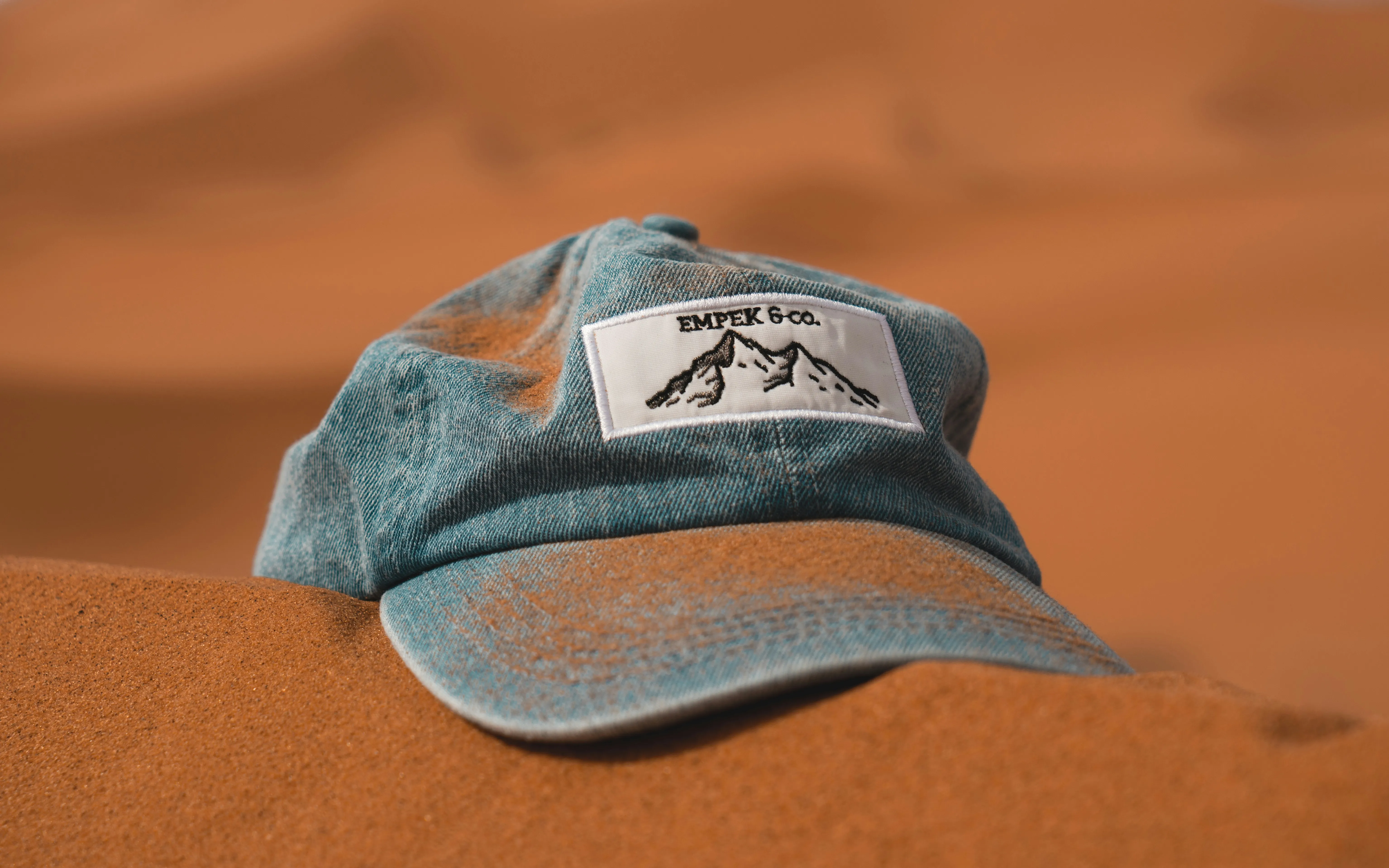 Blue Cap Resting on Sand Representing Simplicity Wallpaper