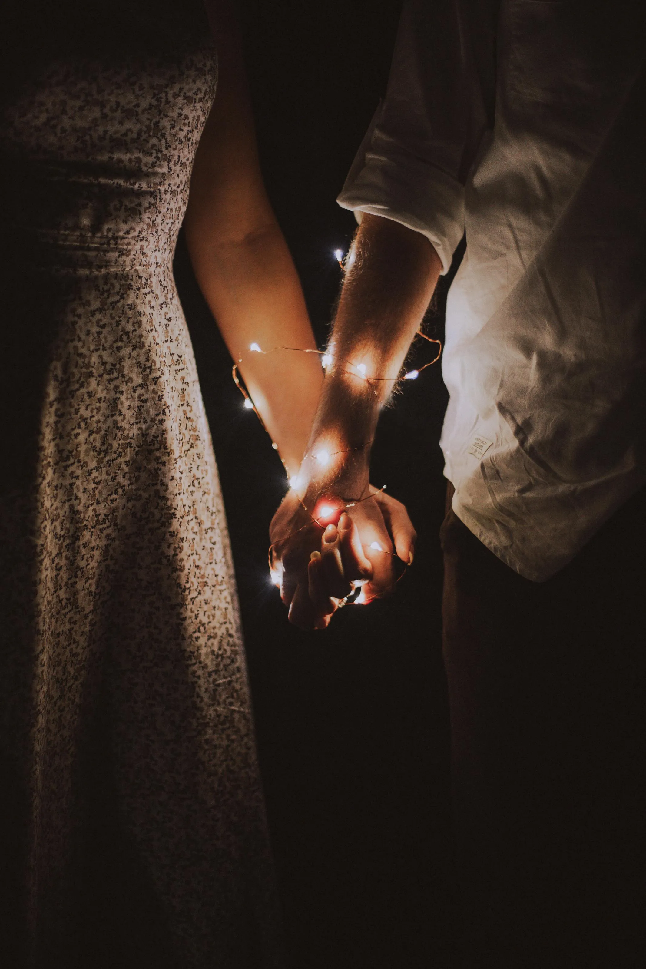 Candlelit Hands Holding Love in Gentle Warmth Wallpaper