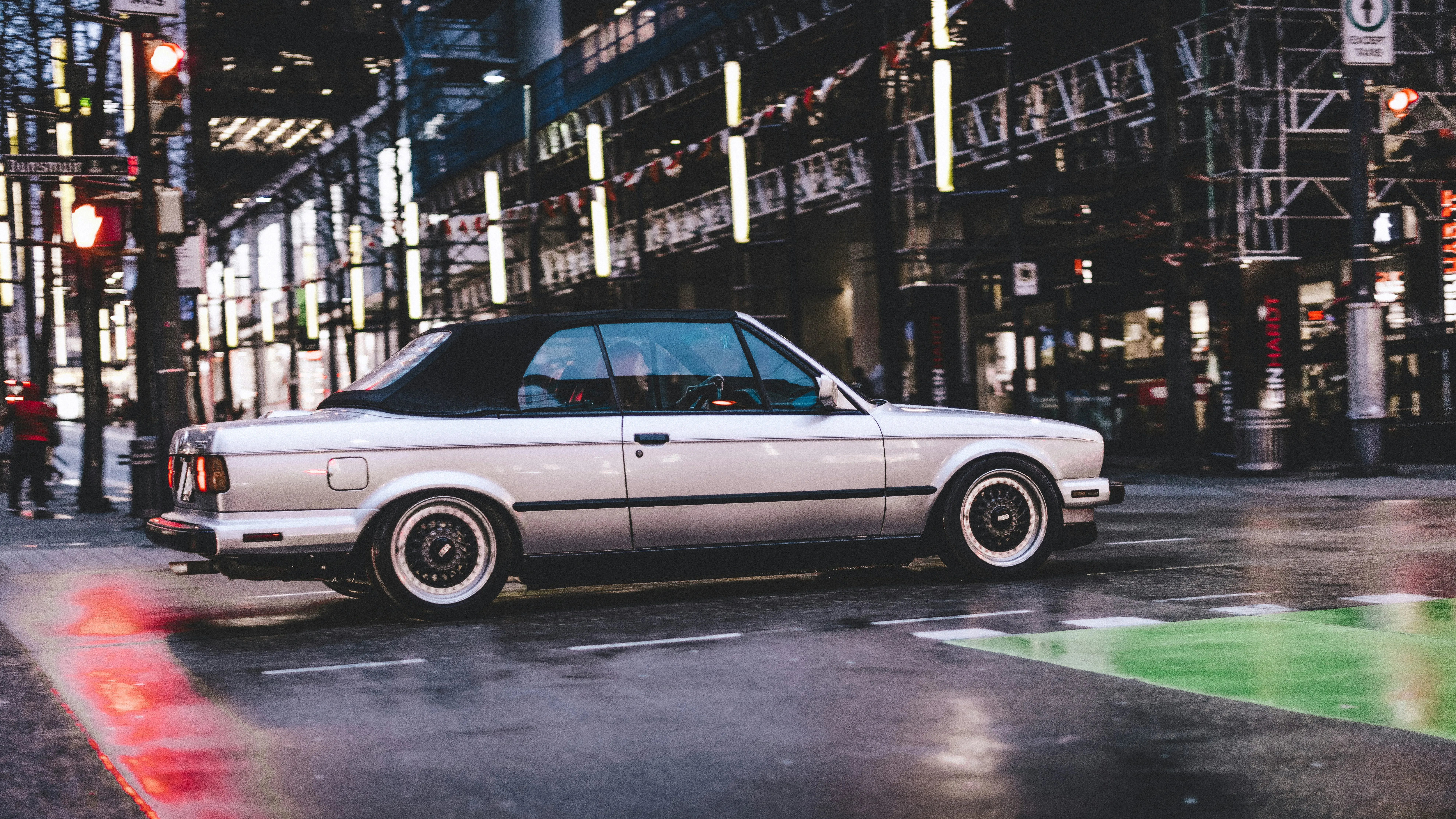 Classic Car Driving Through City Streets at Night Wallpaper