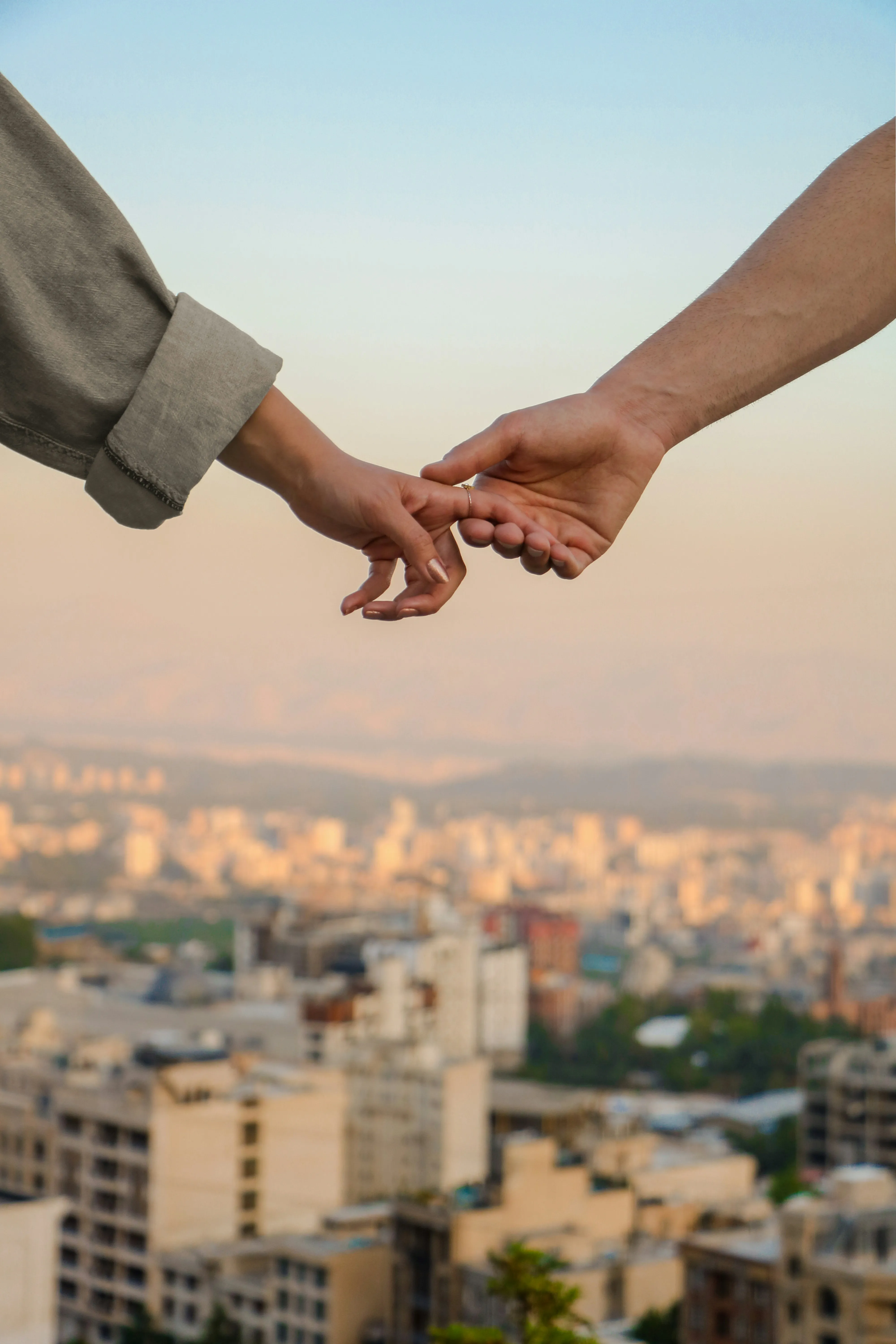 Couple Holding Hands Above Beautiful City View Wallpaper