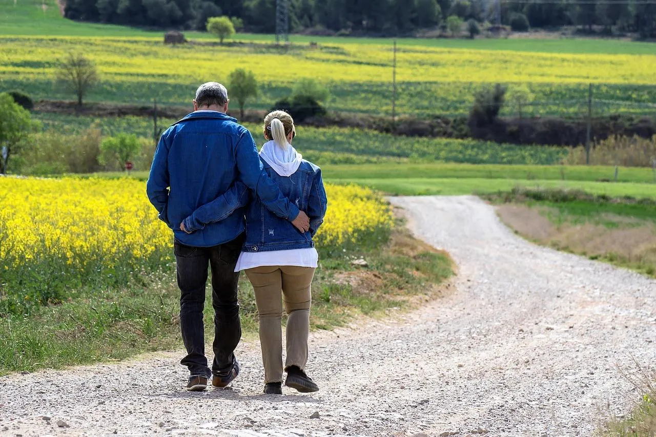 Couple in Field Enjoying Warm Golden Sunshine Wallpaper